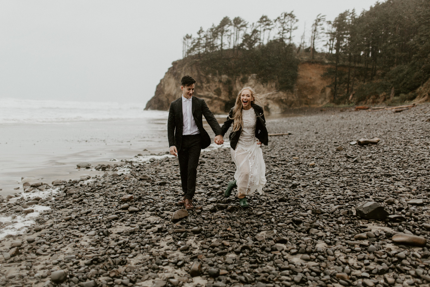 Hannah and Grant walk along the rocks of Hug Point in Cannon Beach, Oregon. Wedding photography in Portland Oregon by Sienna Plus Josh.