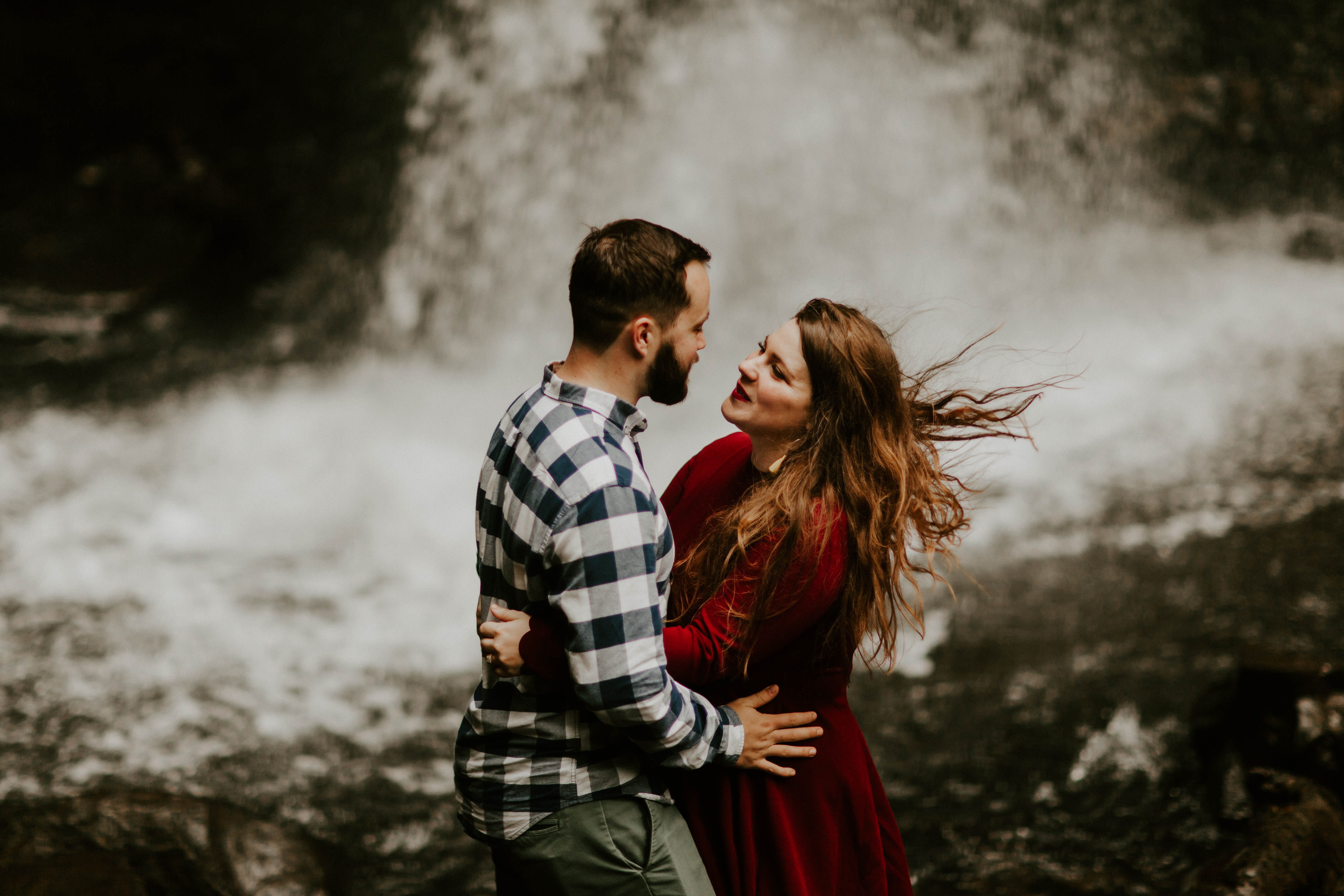 The wind from the waterfall blows Allison's hair at Latourell Falls. Engagement shoot by Sienna Plus Josh.