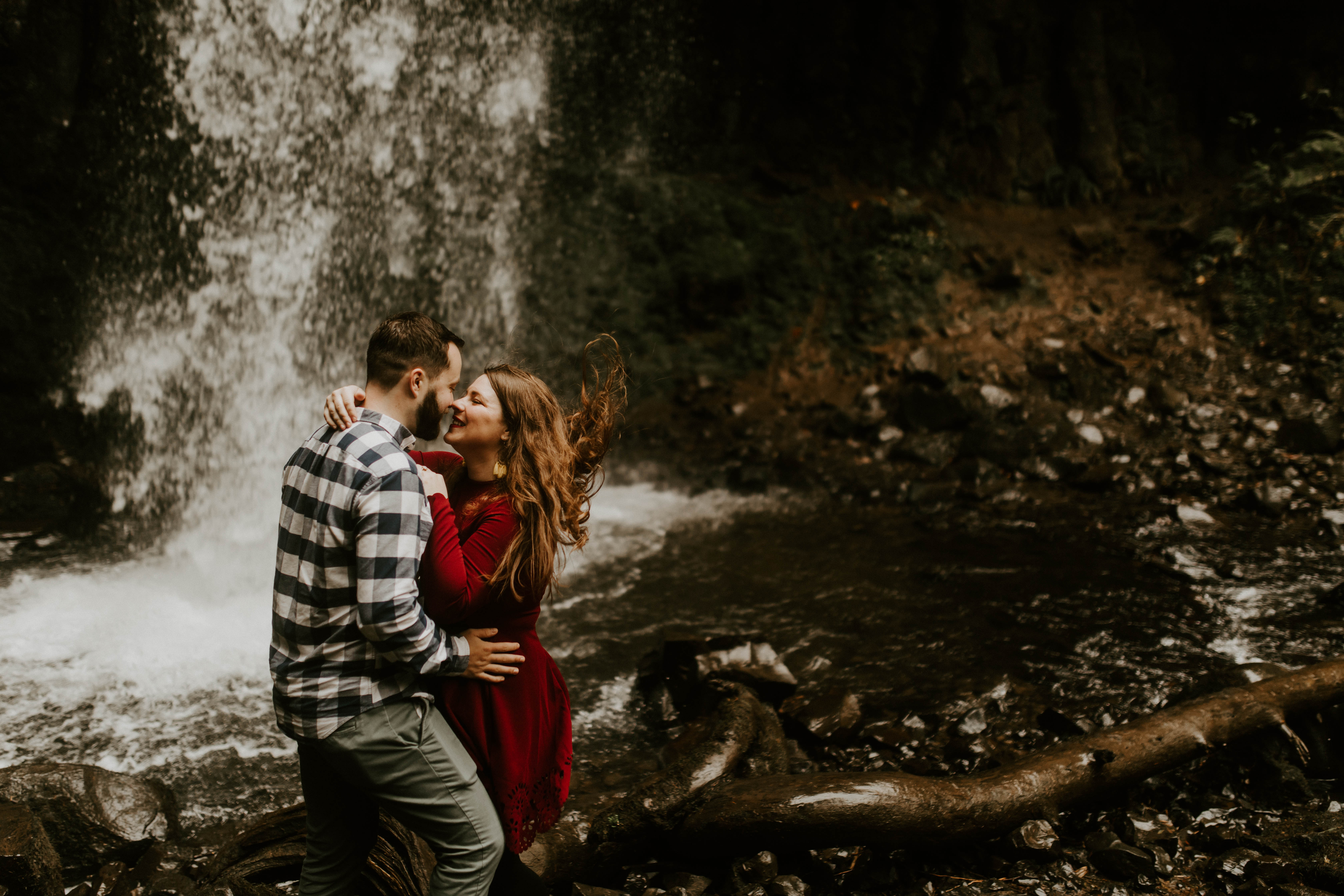 Brandon and Allison move in for a kiss in front of Latourell Falls. Engagement shoot by Sienna Plus Josh.