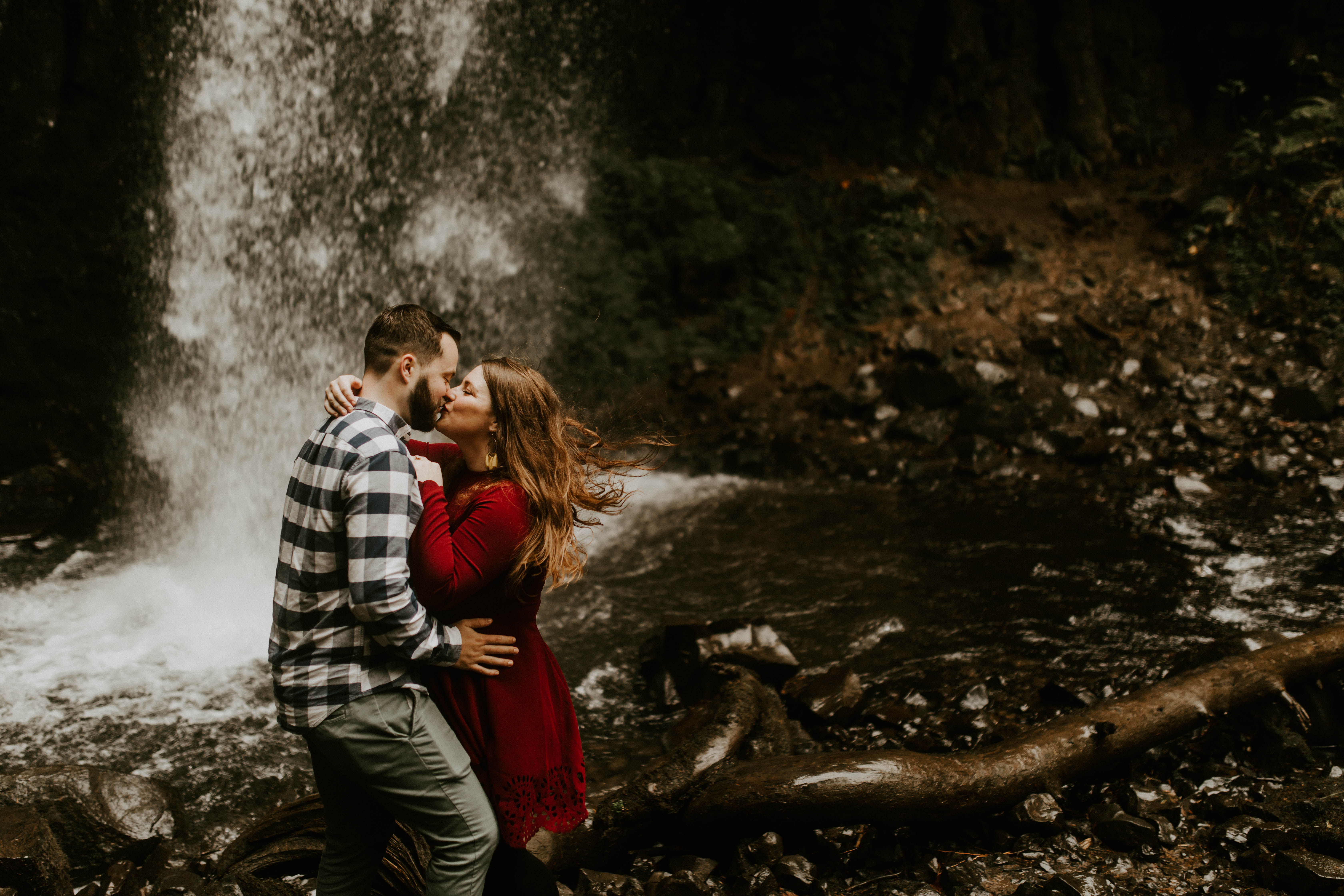 Allison and Brandon kiss in front of Latourell Falls. Engagement shoot by Sienna Plus Josh.