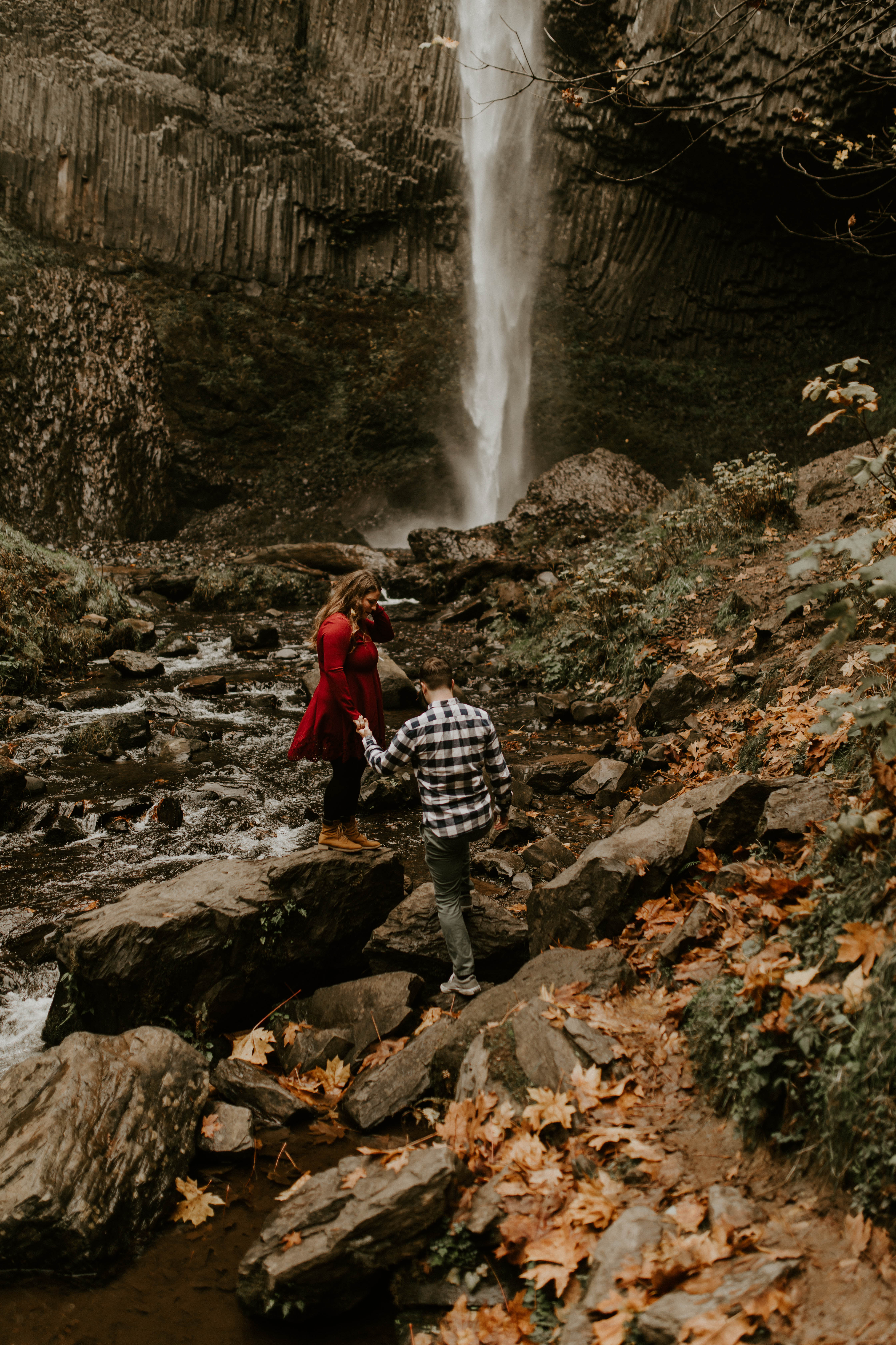 Allison and Brandon walk toward a waterfall at Latourell Falls. Engagement shoot by Sienna Plus Josh.