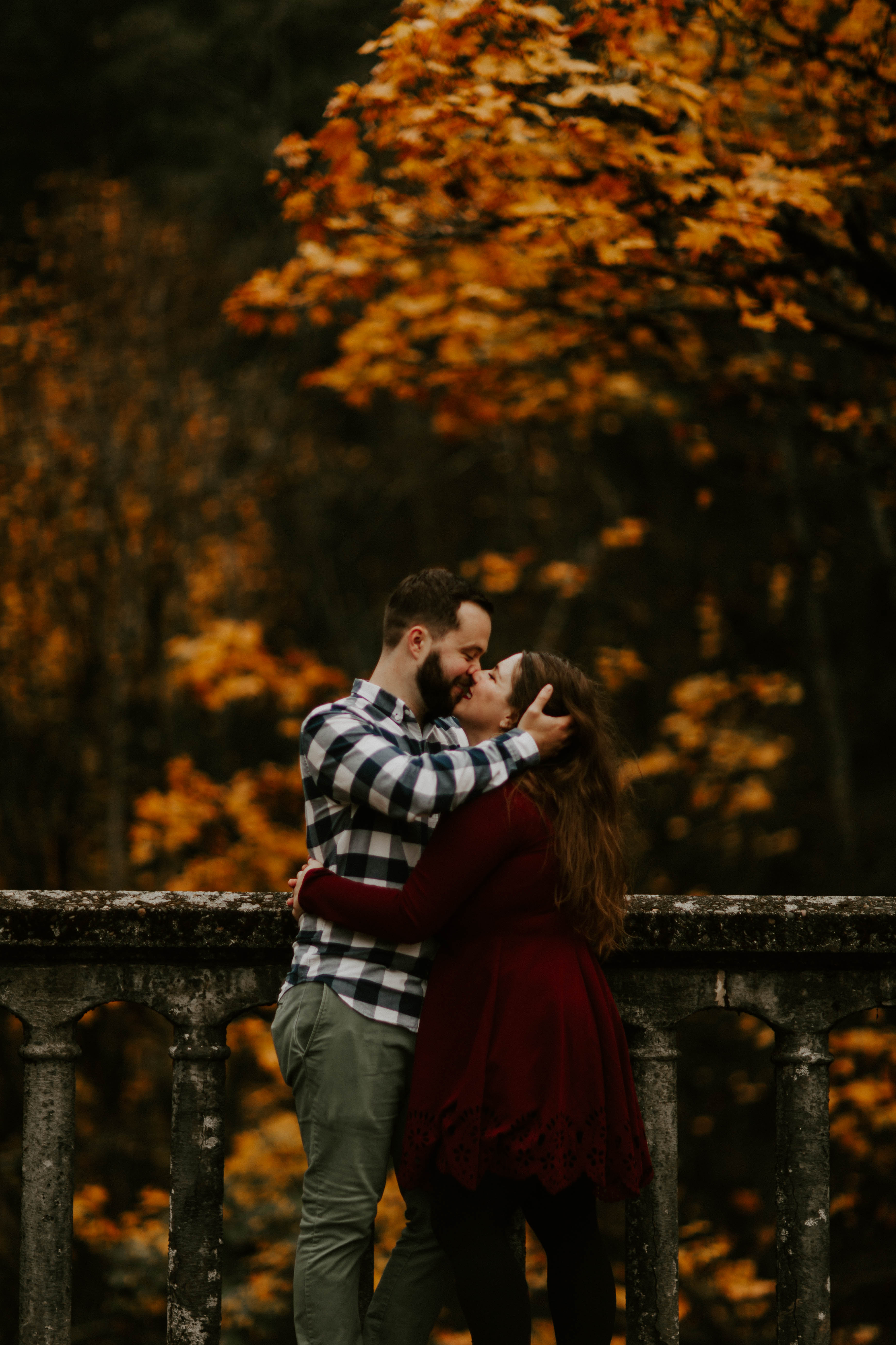 Allison and Brandon kiss on a bridge at Latourell Falls. Engagement shoot by Sienna Plus Josh.