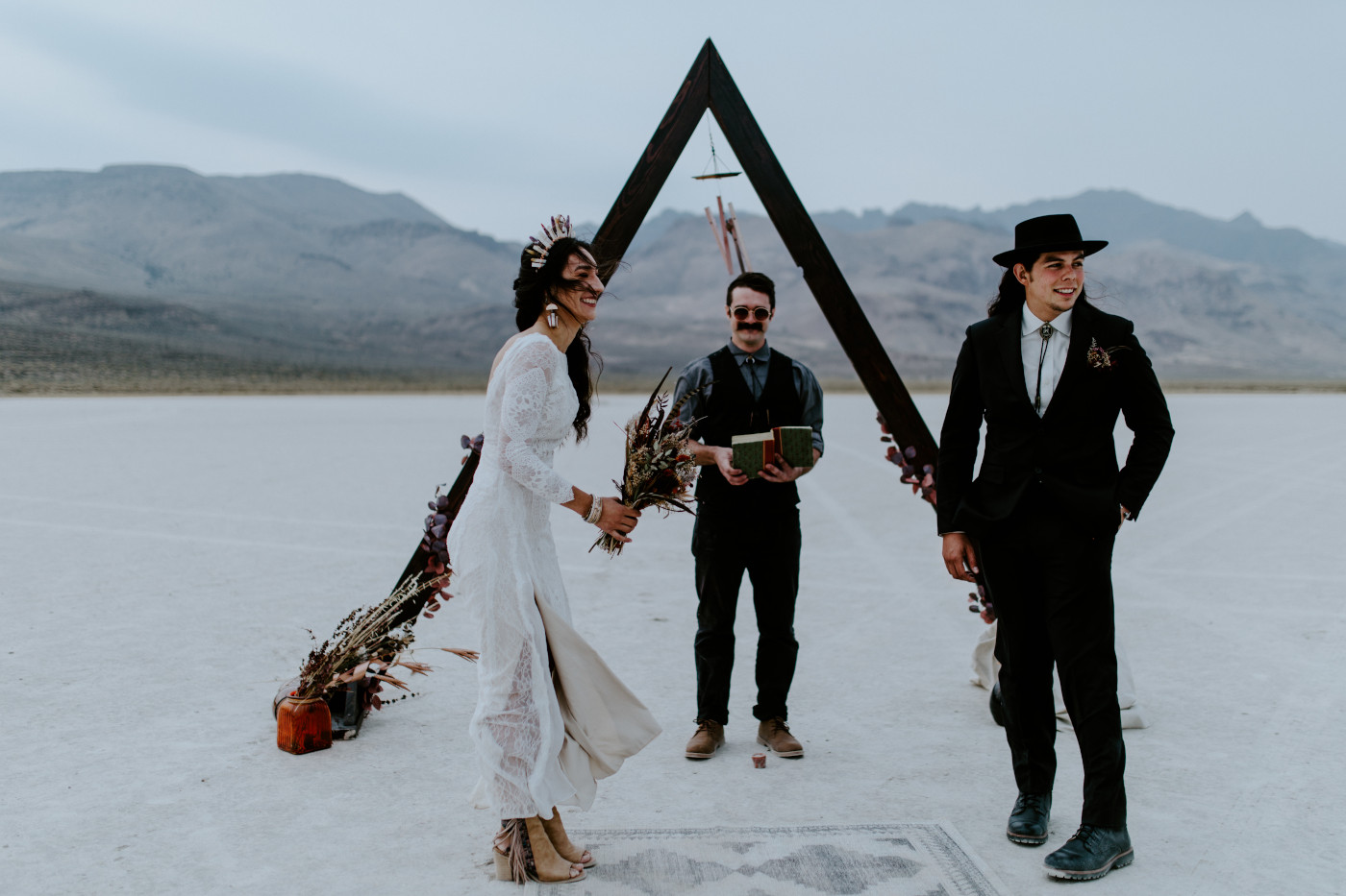 Cameron and Emerald laugh during their elopement ceremony with the mountains near Alvord Desert in the background.