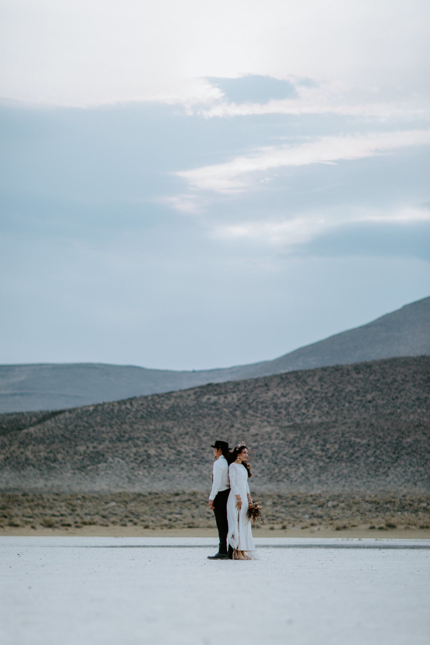 Cameron and Emerald stand back to back in the Alvord Desert after their elopement ceremony.
