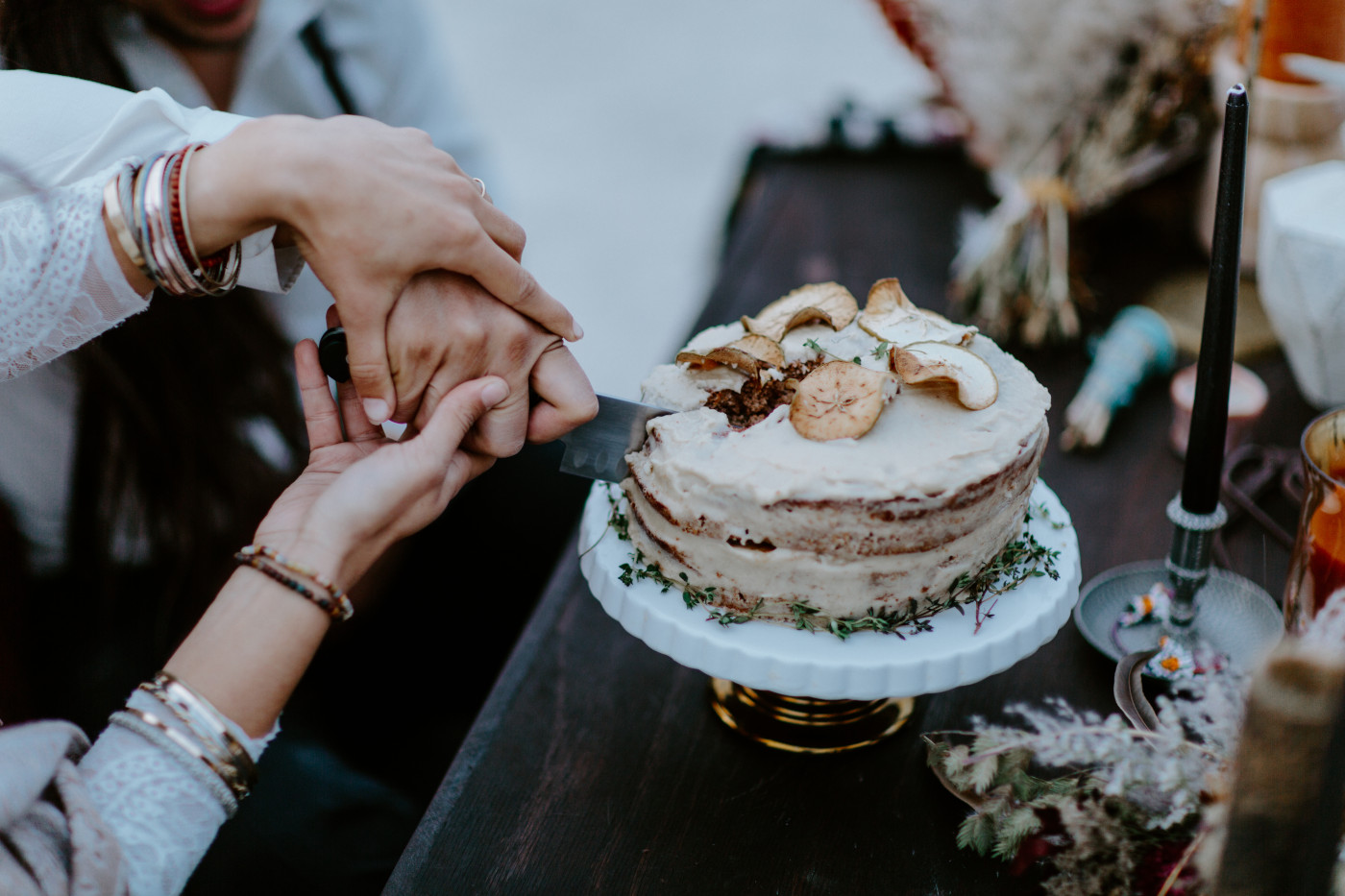 A close up of Cameron and Emerald cutting their elopement cake.