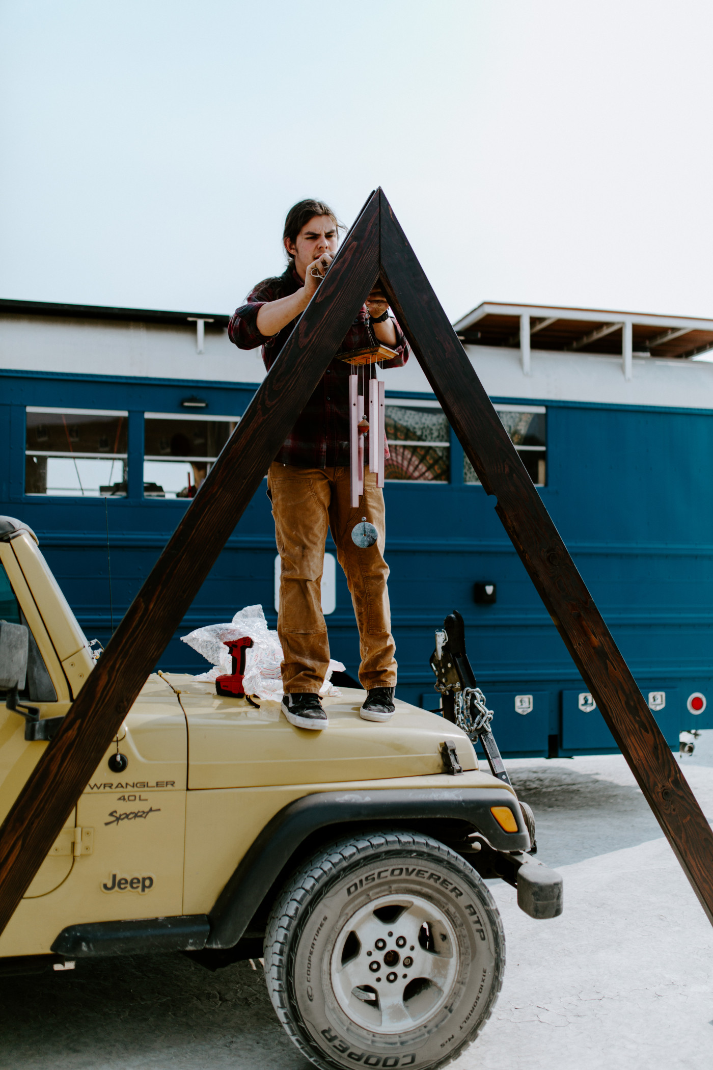 Cameron attaches a wind chime to the A frame altar.