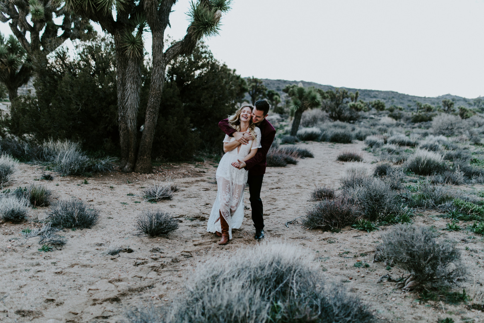 Alyssa holds Jeremy as they sit at Joshua Tree National Park, CA Elopement wedding photography at Joshua Tree National Park by Sienna Plus Josh.