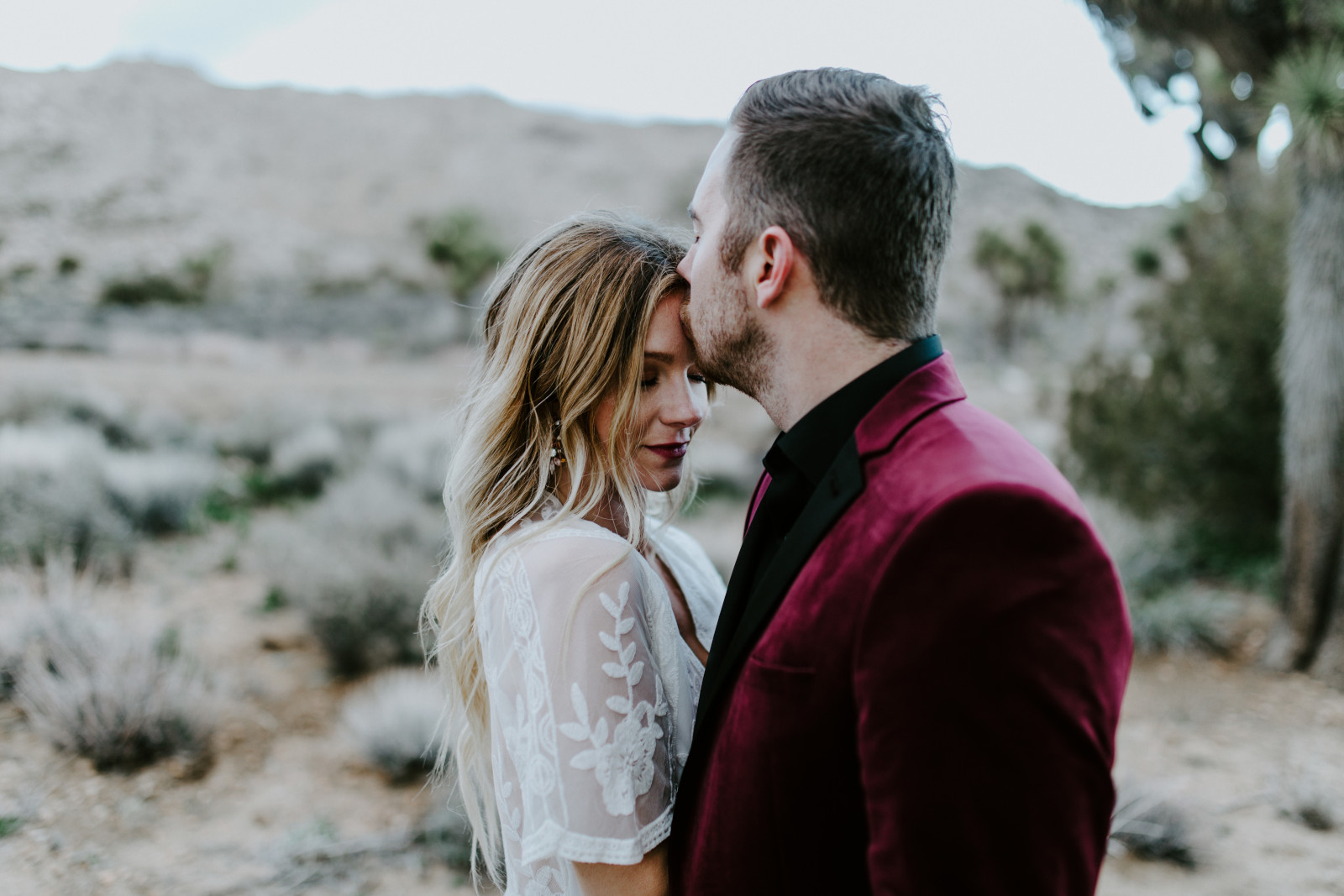 Alyssa and Jeremy kiss as they lay in the sand at Joshua Tree. Elopement wedding photography at Joshua Tree National Park by Sienna Plus Josh.