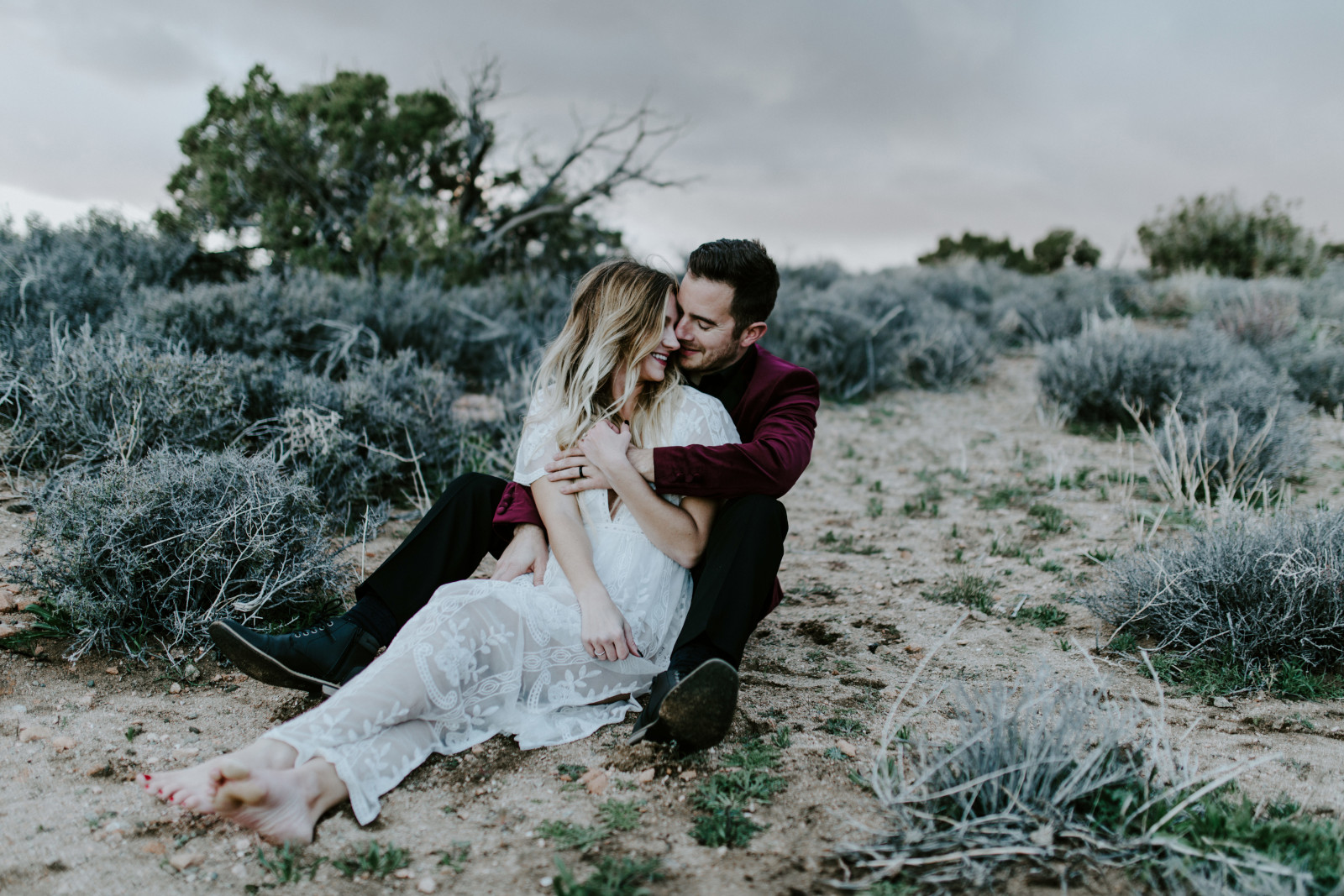 Alyssa and Jeremy sit on the sand at Joshua Tree. Elopement wedding photography at Joshua Tree National Park by Sienna Plus Josh.