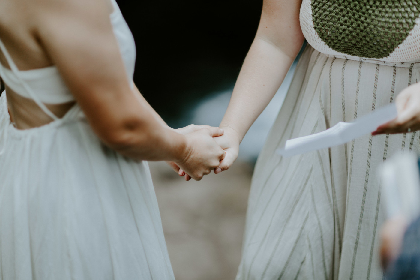 Audrey and Kate holding hands at Bridal Veil Falls. Elopement wedding photography at Bridal Veil Falls by Sienna Plus Josh.