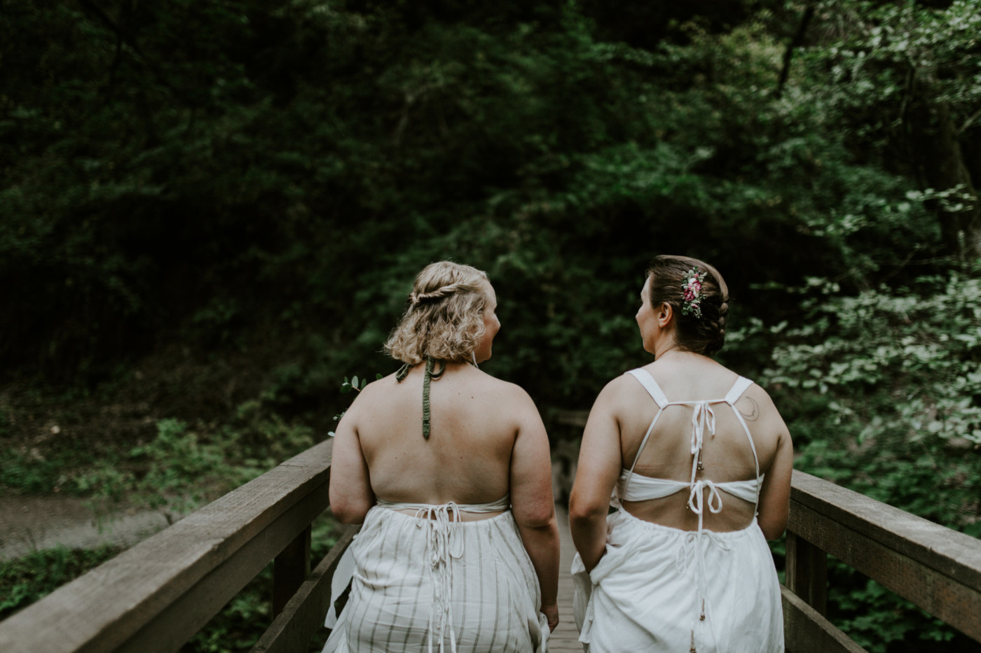 Kate and Audrey cross a bridge toward Bridal Veil Falls. Elopement wedding photography at Bridal Veil Falls by Sienna Plus Josh.