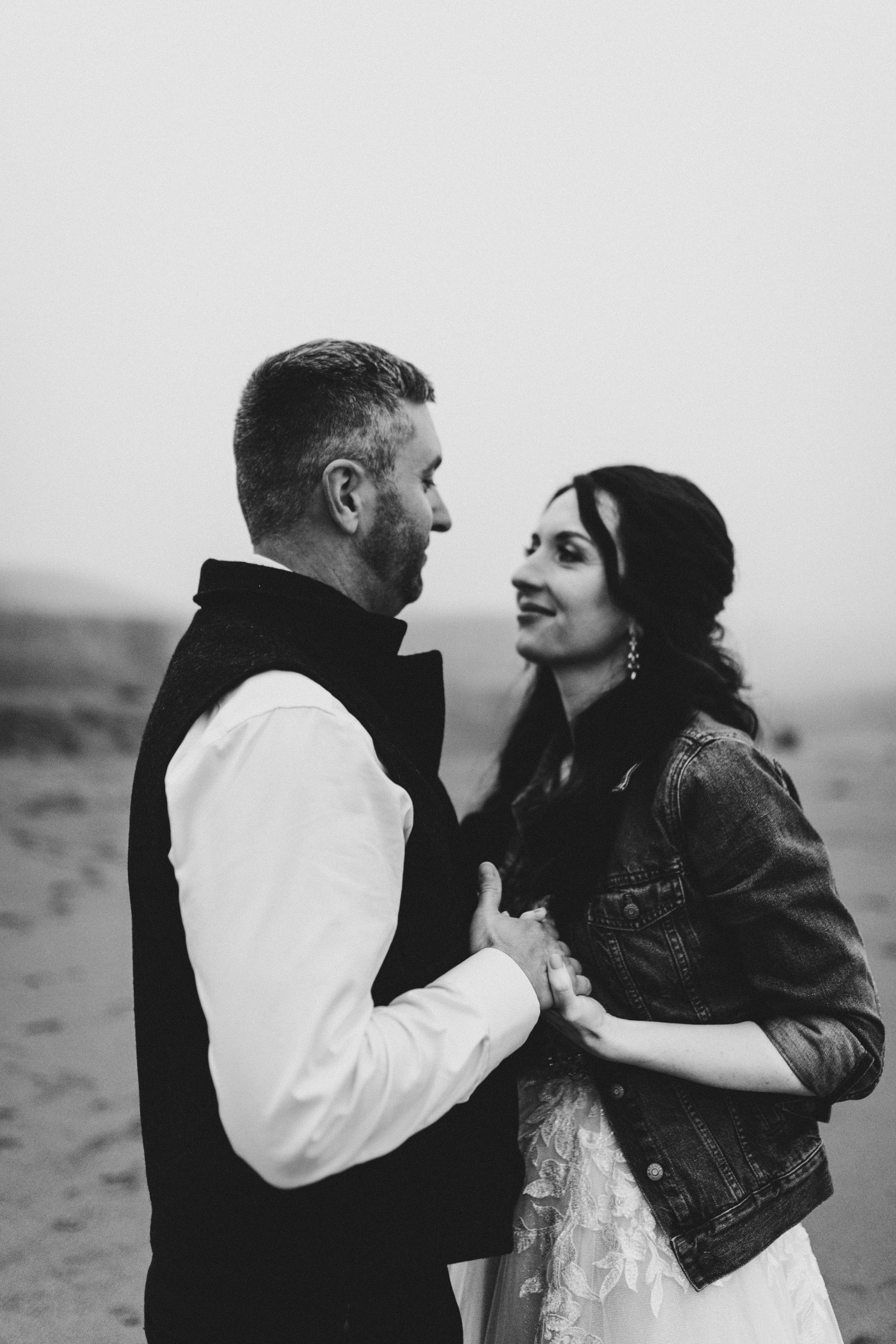 Tim and Hannah hold hands on the beach.