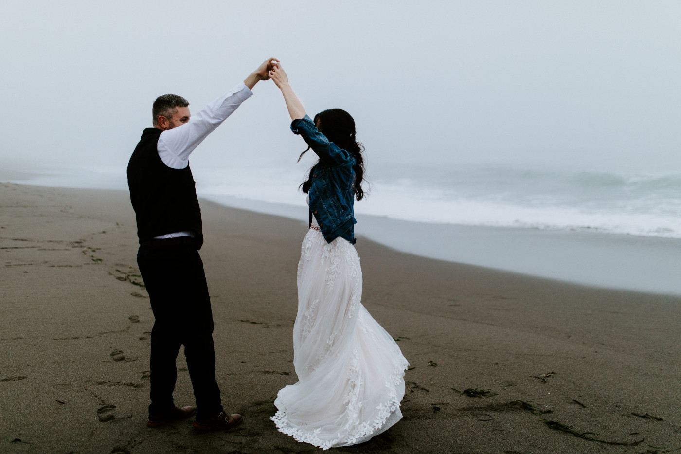 Tim spins Hannah as they dance on the beach.