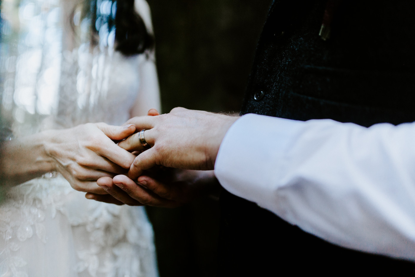 Hannah puts a ring on Tim's hand.