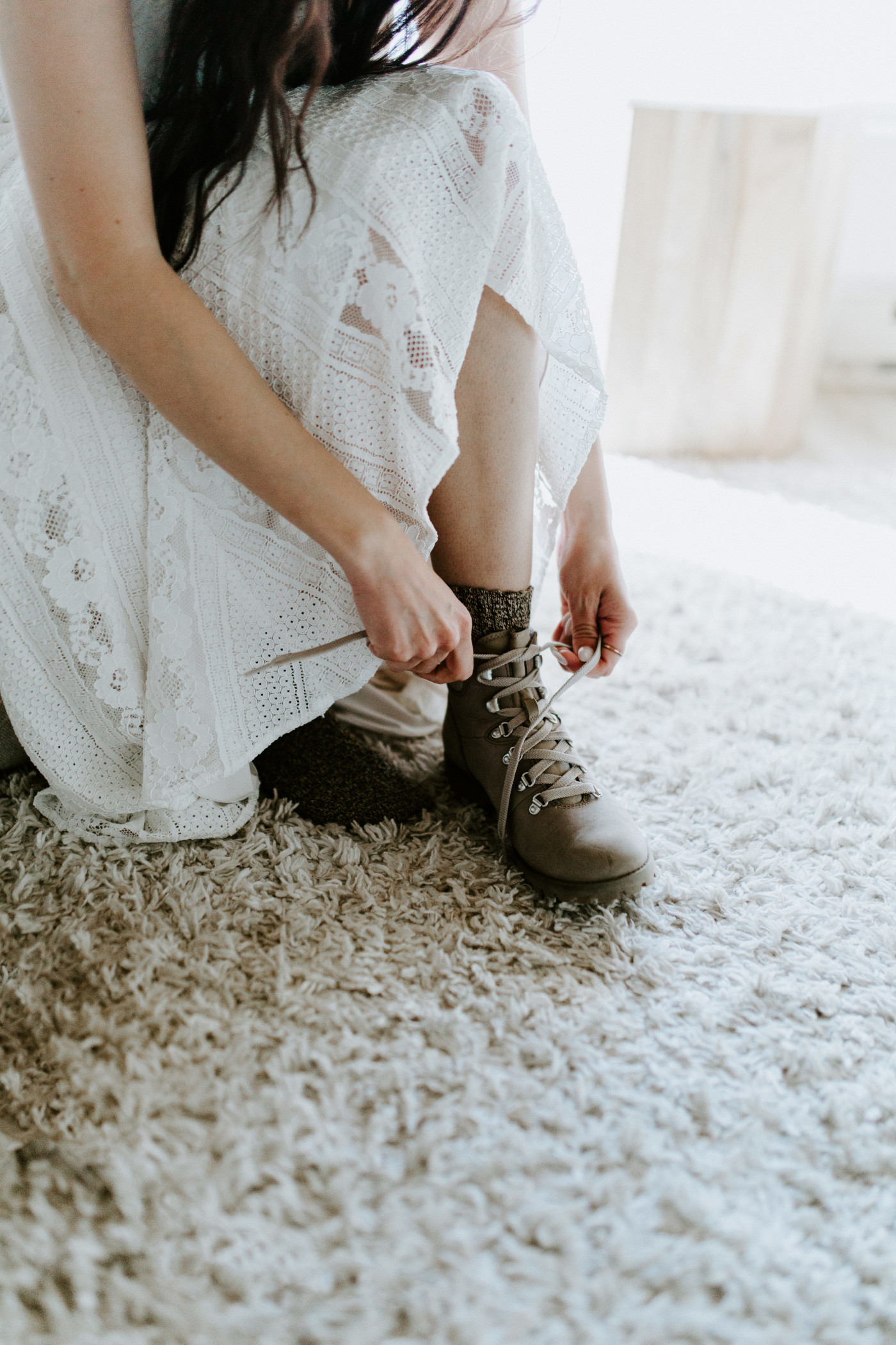 Allison ties her hiking boots in her AirBnB.