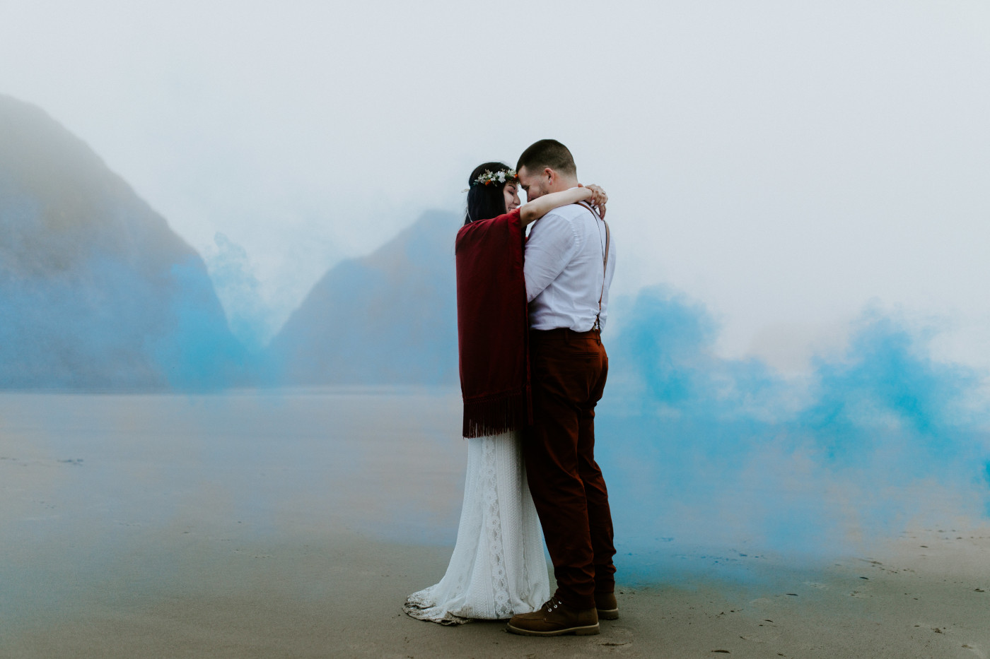 Allison and TJ hug with a blue smoke surrounding them.