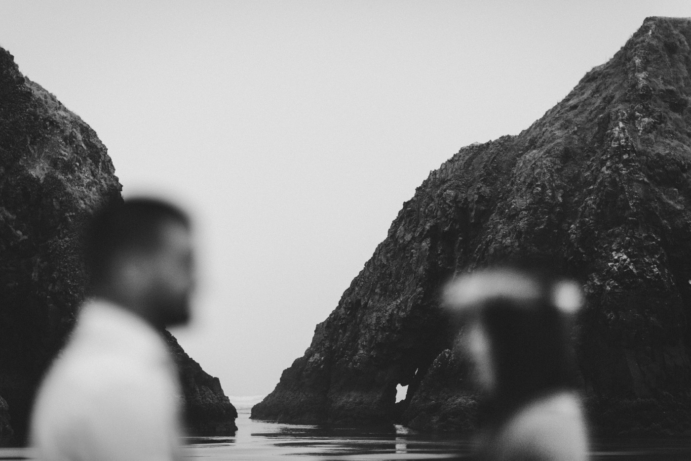 The rocks on Cannon Beach behind Allison and TJ.