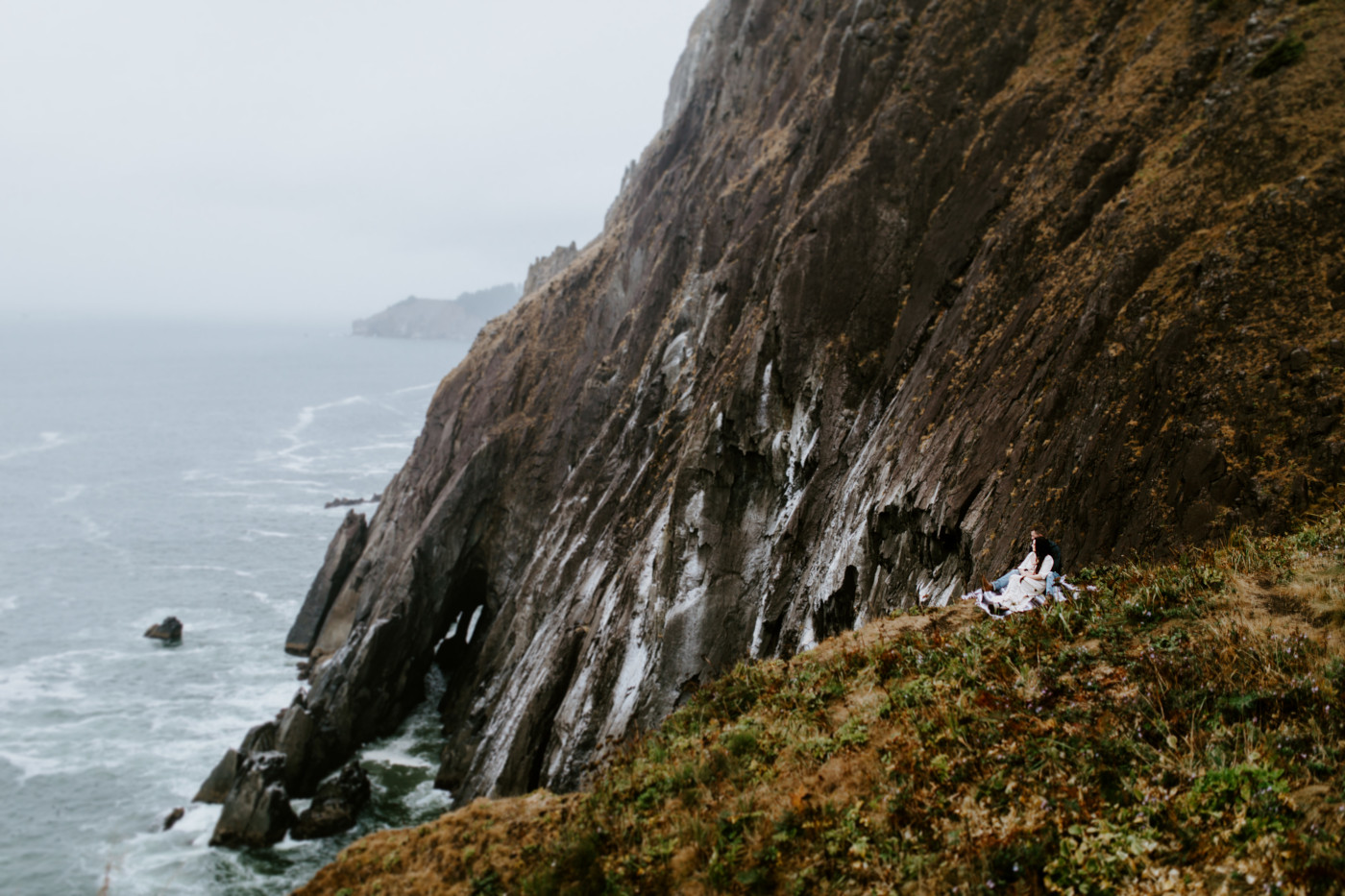 Allison and TJ sit near the cliff.