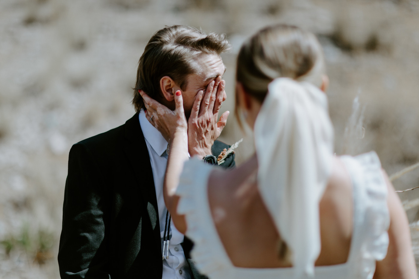 Emily helps wipe away Greyson's tears. Elopement photography in the Central Oregon desert by Sienna Plus Josh.