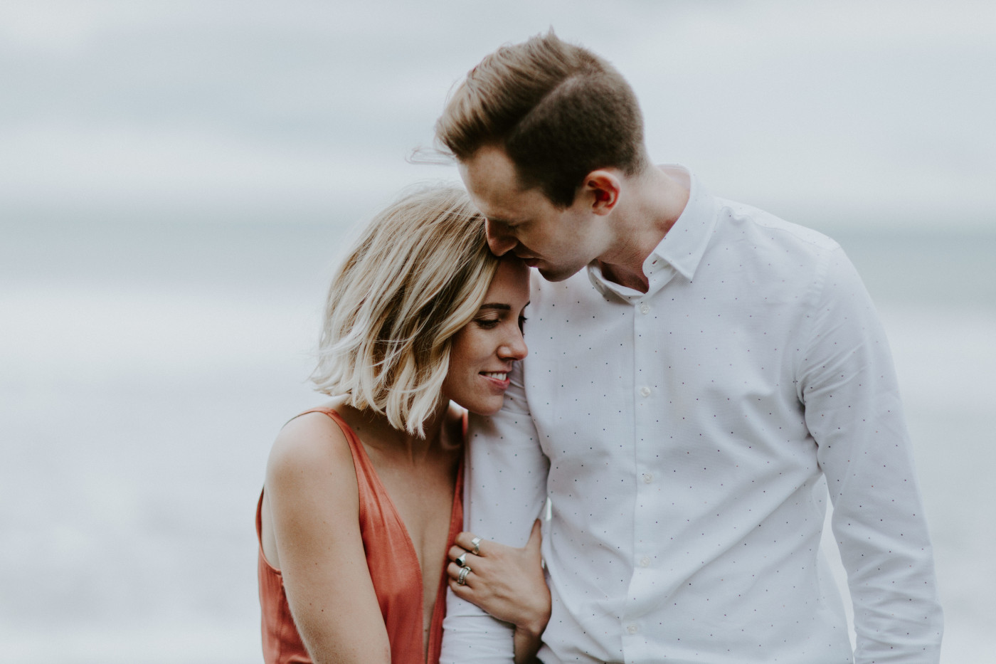 Chelsey hugs Billy's arm. Elopement wedding photography at Cannon Beach by Sienna Plus Josh.