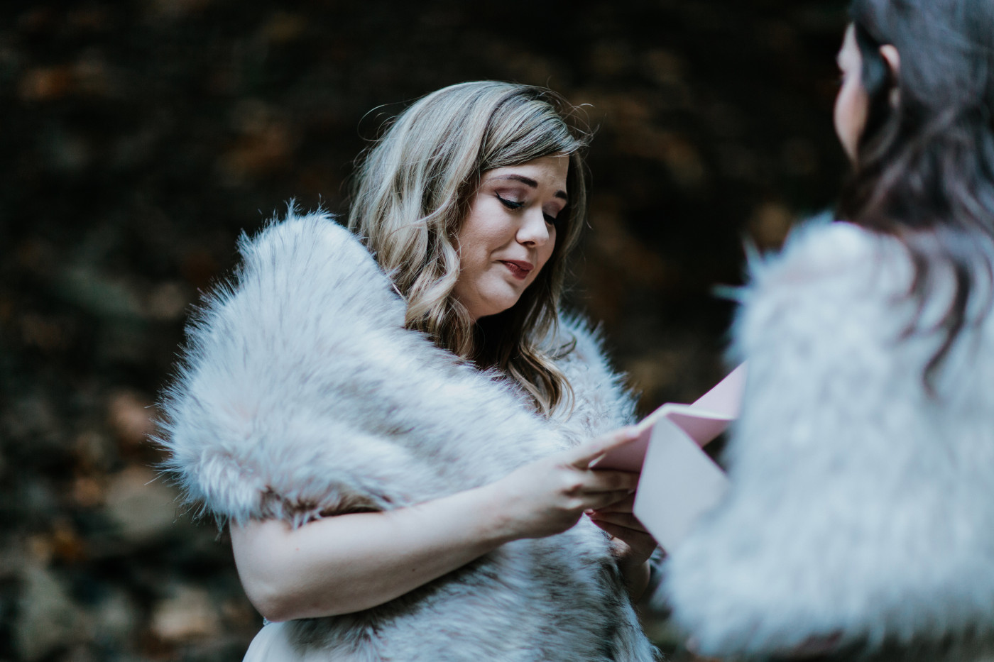 Hayley and Tiffany stand together while reading vows. Elopement photography at the Columbia River Gorge by Sienna Plus Josh.