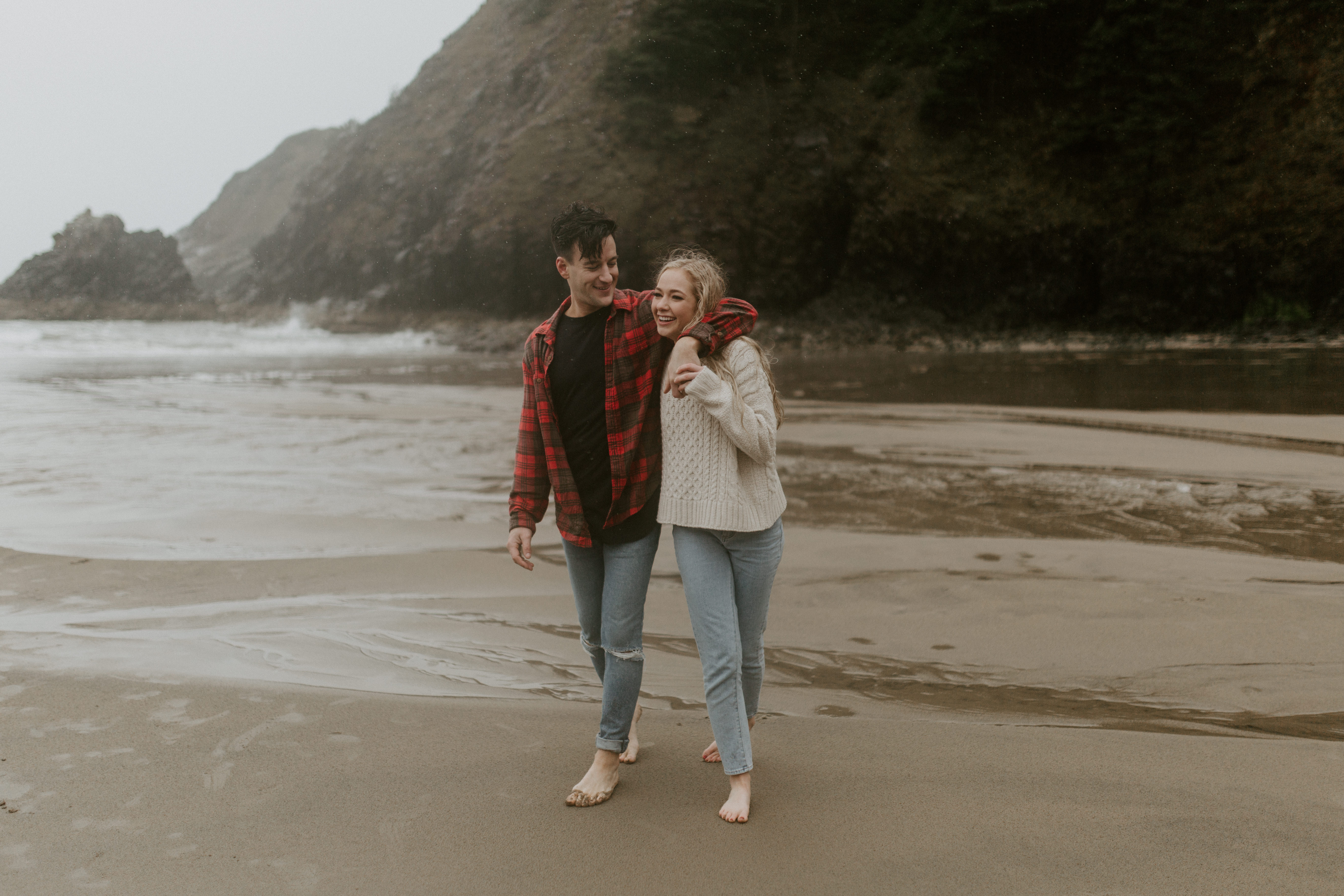 Hannah pulls Grant towards the waves on Indian Beach in Ecola State Park, Oregon. Engagement photography in Oregon by Sienna Plus Josh.