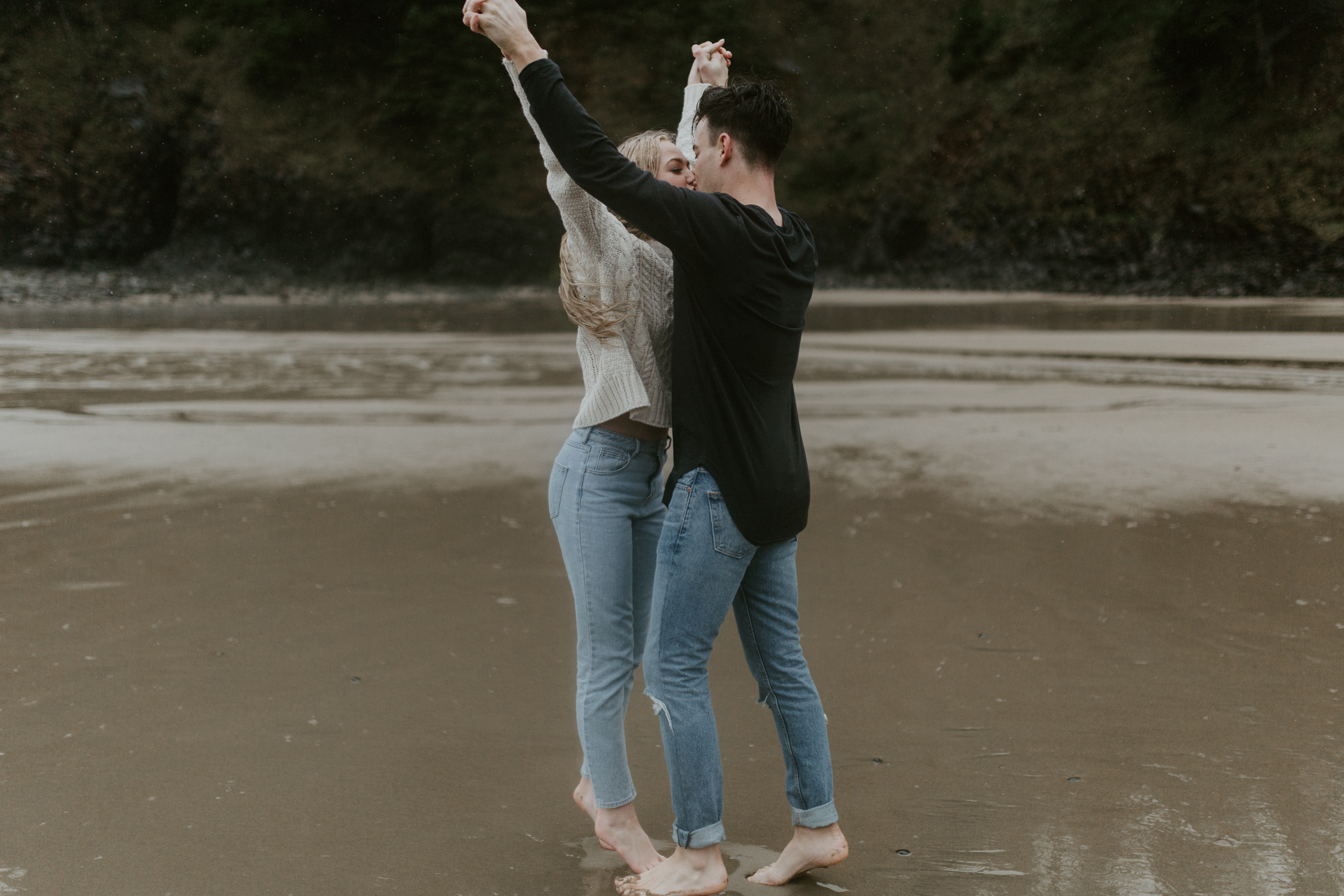 Hannah and Grant kiss on Indian Beach in Ecola State Park, Oregon. Engagement photography in Oregon by Sienna Plus Josh.