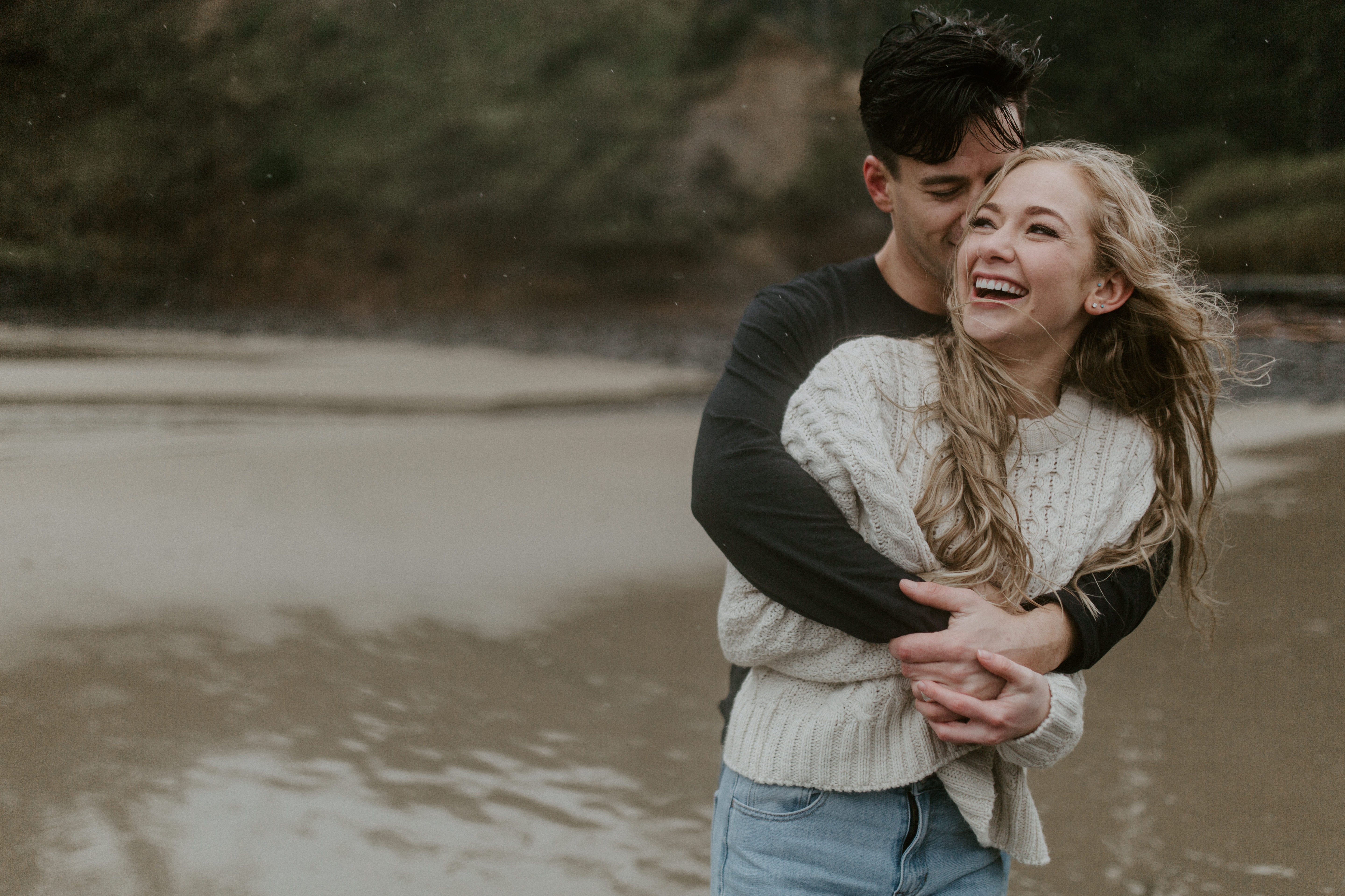 Grant hugs Hannah on Indian Beach in Ecola State Park, Oregon. Engagement photography in Oregon by Sienna Plus Josh.