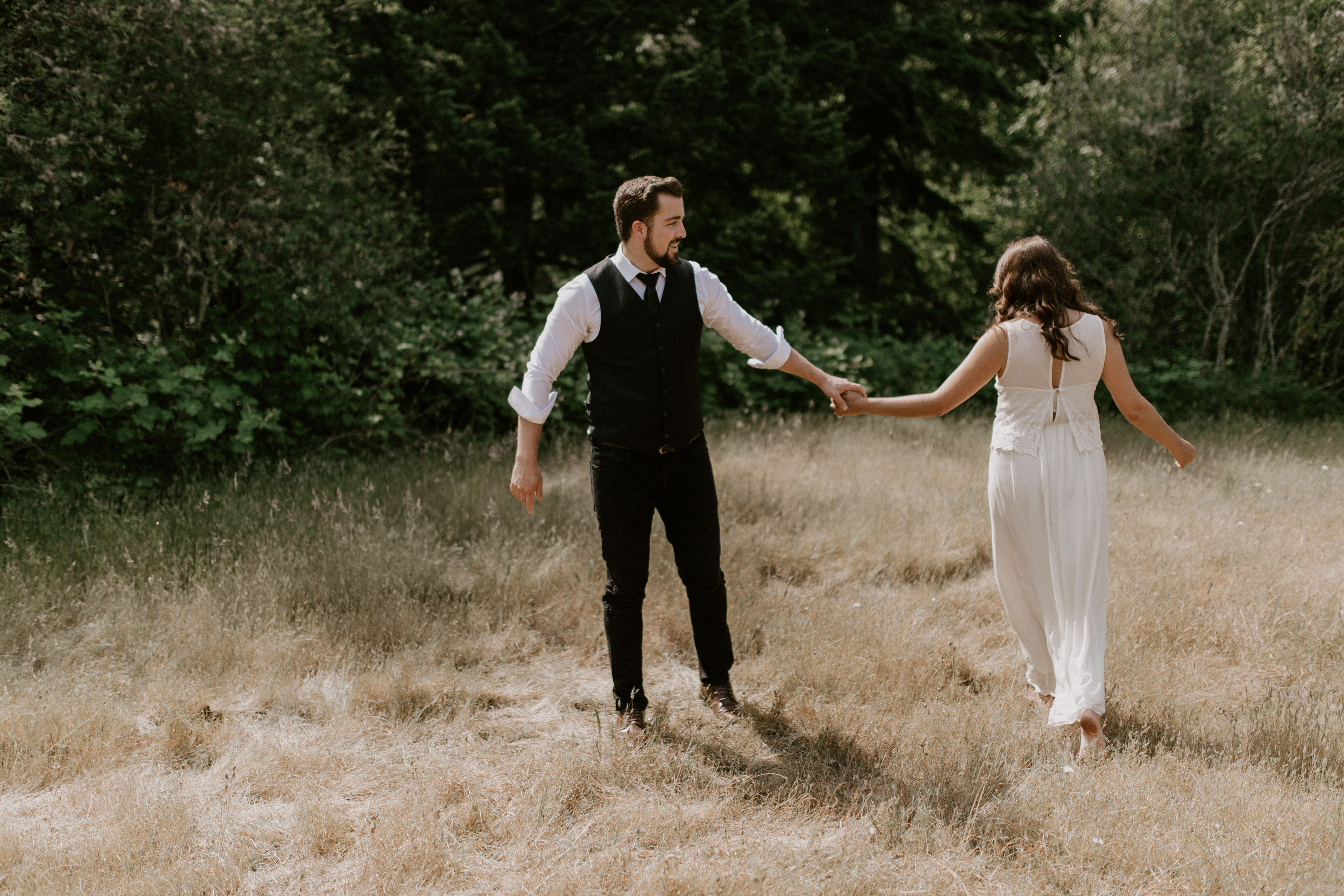 Emily and Josh holding hands and walking at Bridal Veil Falls, Oregon. Elopement photography in Portland Oregon by Sienna Plus Josh.