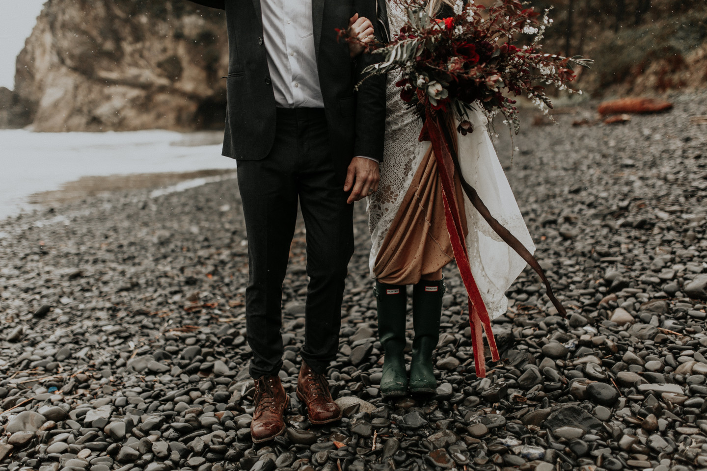 Hannah and Grant stand on the rocks in Cannon Beach, Oregon. Wedding photography in Portland Oregon by Sienna Plus Josh.