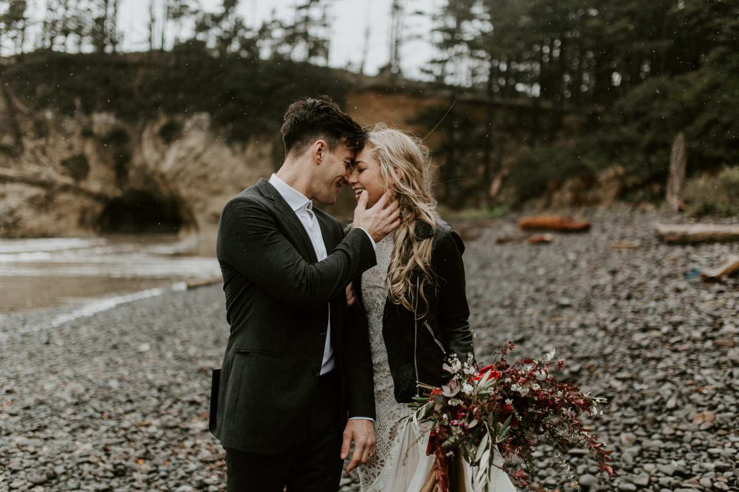 Grant touches Hannah's face on the rocks of Cannon Beach, Oregon. Wedding photography in Portland Oregon by Sienna Plus Josh.