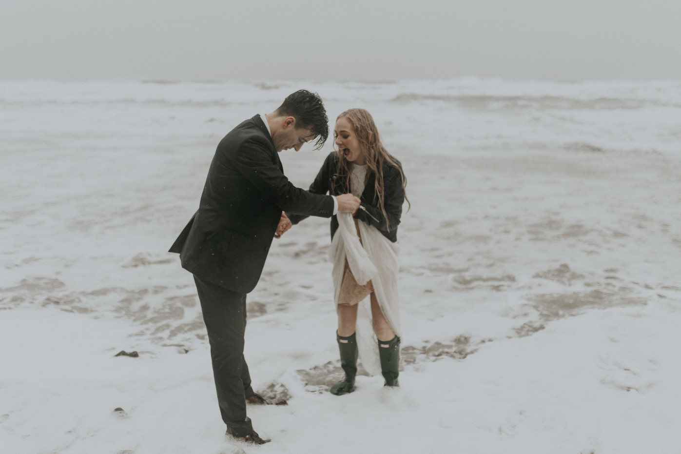 Hannah and Grant get their feet wet at the shore of Hug Point in Cannon Beach, Oregon during their elopement. Wedding photography in Portland Oregon by Sienna Plus Josh.
