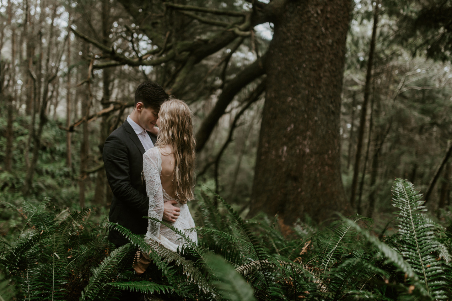 Hannah and Grant stand in the ferns in Cannon Beach, Oregon for their Oregon coast elopement. Wedding photography in Portland Oregon by Sienna Plus Josh.