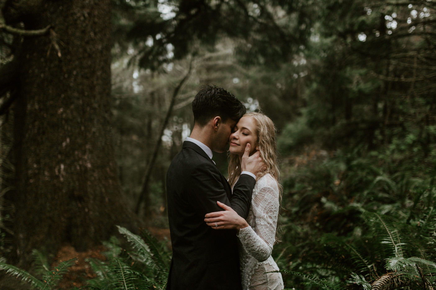 Hannah and Grant stand under a tree in Cannon Beach, Oregon. Wedding photography in Portland Oregon by Sienna Plus Josh.