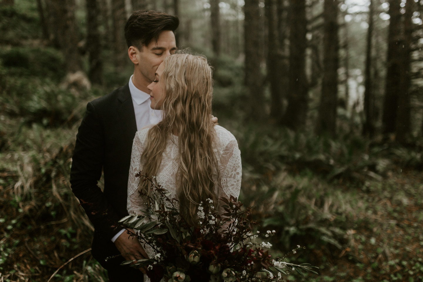 Hannah Grant hug in the treeline of Cannon Beach, Oregon during their elopement. Wedding photography in Portland Oregon by Sienna Plus Josh.