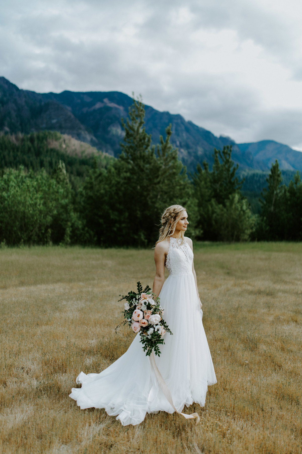 Harper stands alone with her boquet at the Columbia River Gorge in Oregon. Elopement photography in Portland Oregon by Sienna Plus Josh.