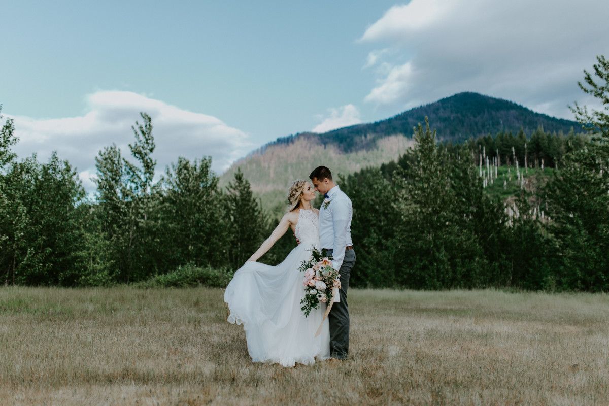 Harper holds her dress while facing Trevor at the Columbia Gorge, Oregon. Elopement photography in Portland Oregon by Sienna Plus Josh.