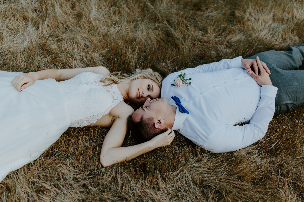 Harper and Trever lay on the ground at Cascade Locks at the Columbia Gorge, Oregon. Elopement photography in Portland Oregon by Sienna Plus Josh.