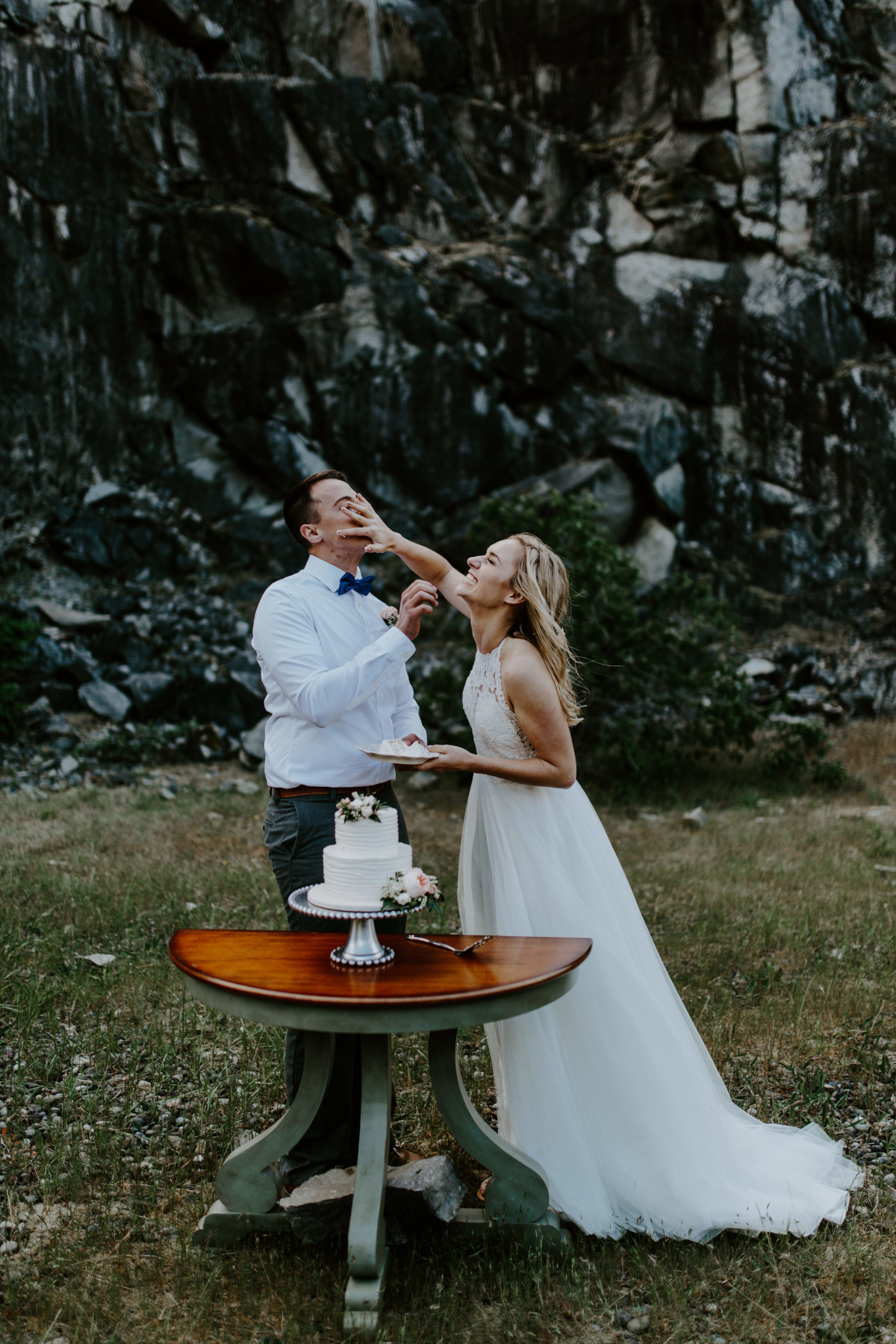 Harper smashes cake into Trevor's face at Cascade Locks at the Columbia Gorge, Oregon. Elopement photography in Portland Oregon by Sienna Plus Josh.