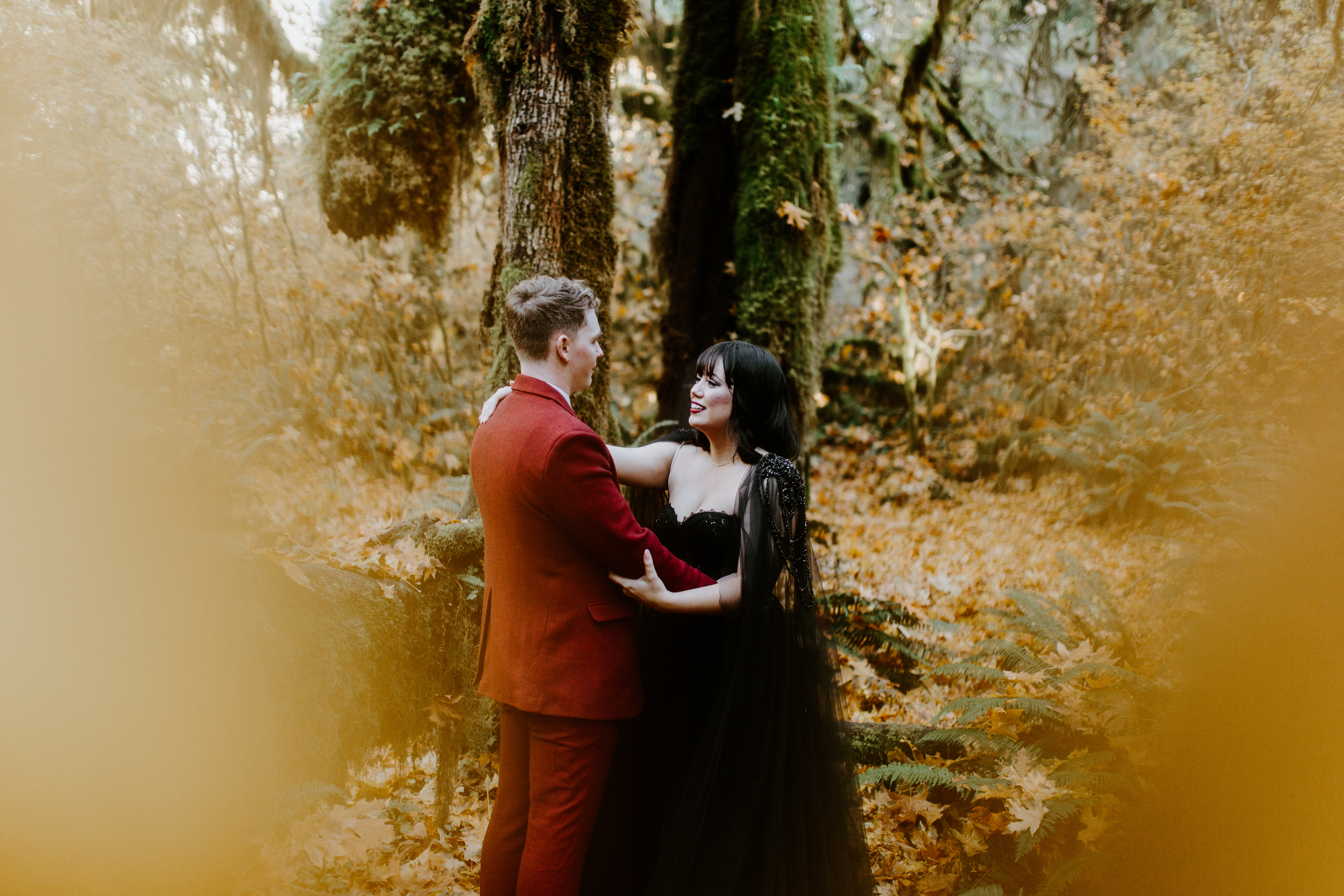 Bethany and Brett stand together in the trees and moss of the Hoh Rainforest.
