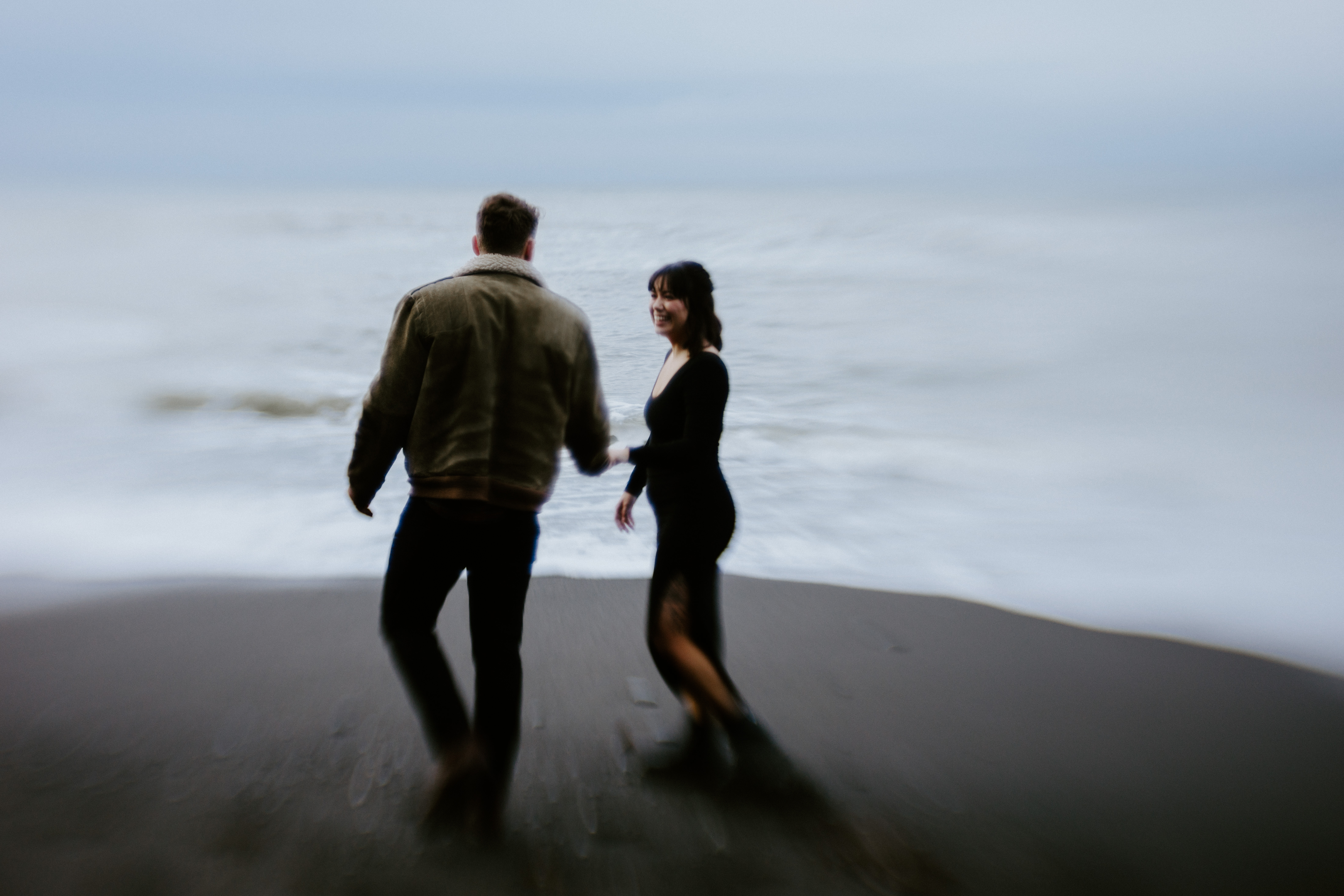 Bethany smiles at Brett while they walk on the each at Rialto Beach, Washington.