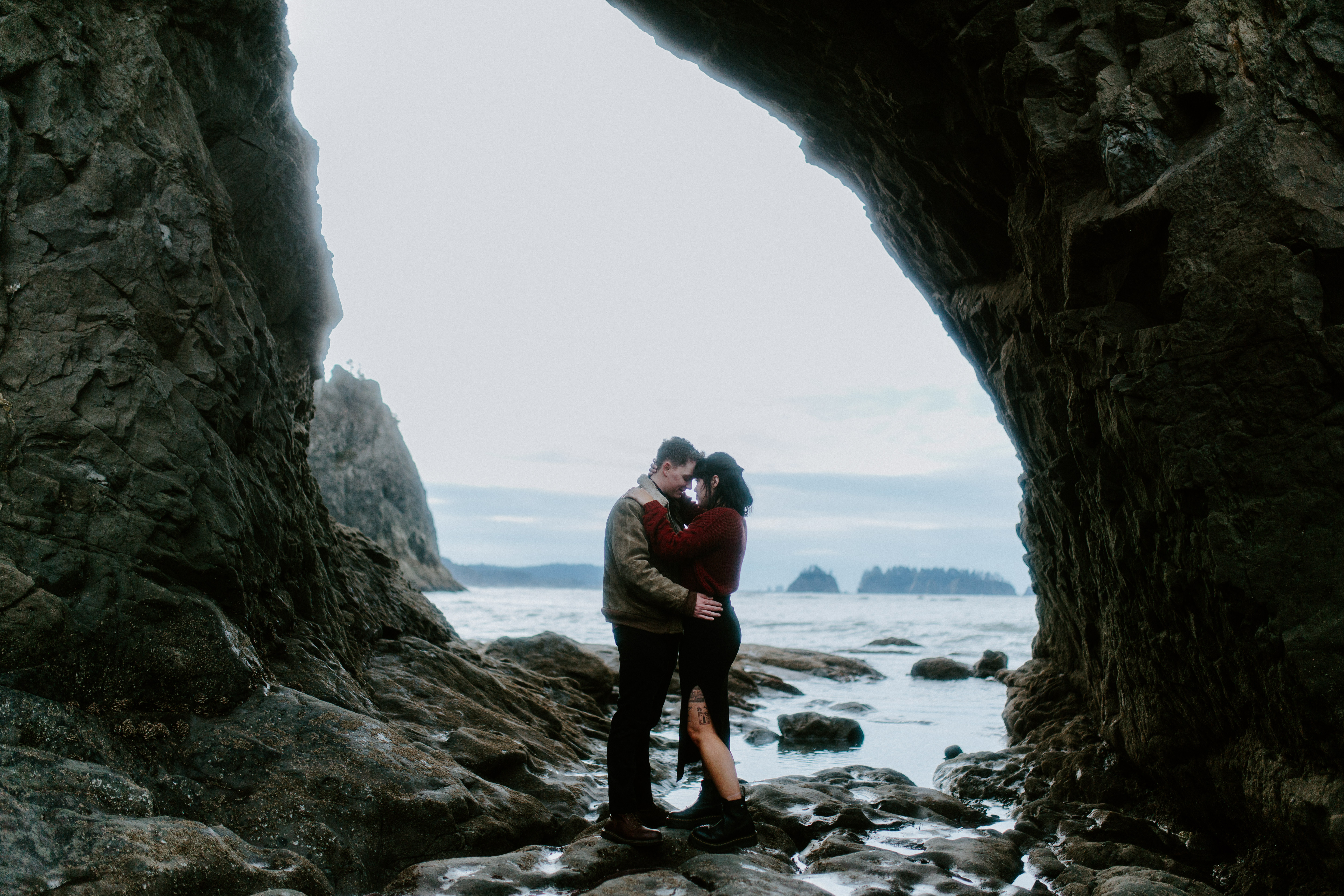Bethany and Brett stand with their foreheads together at Rialto Beach, Washington.