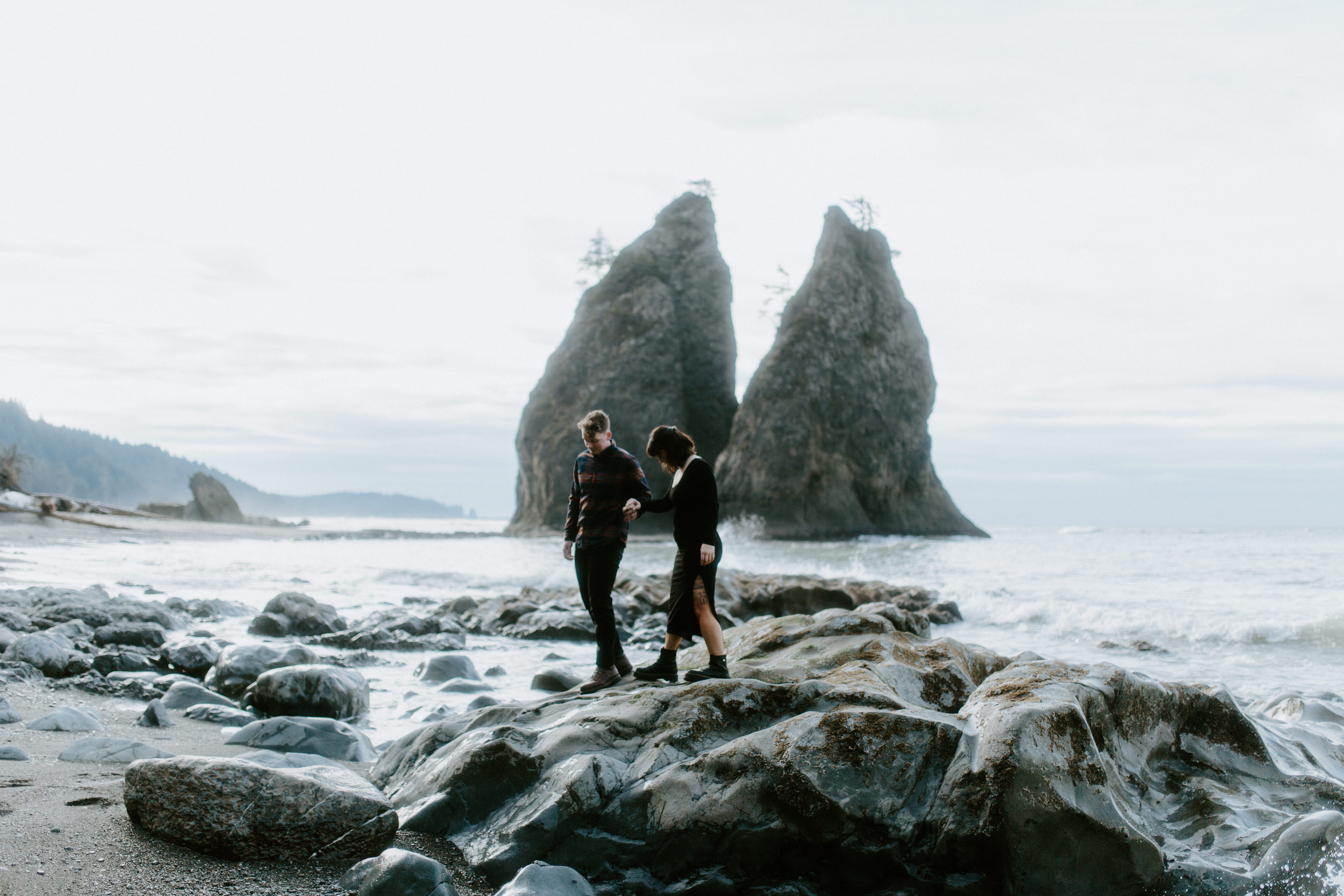 Bethany and Brett hold hands while walking on the rocks of Rialto Beach.