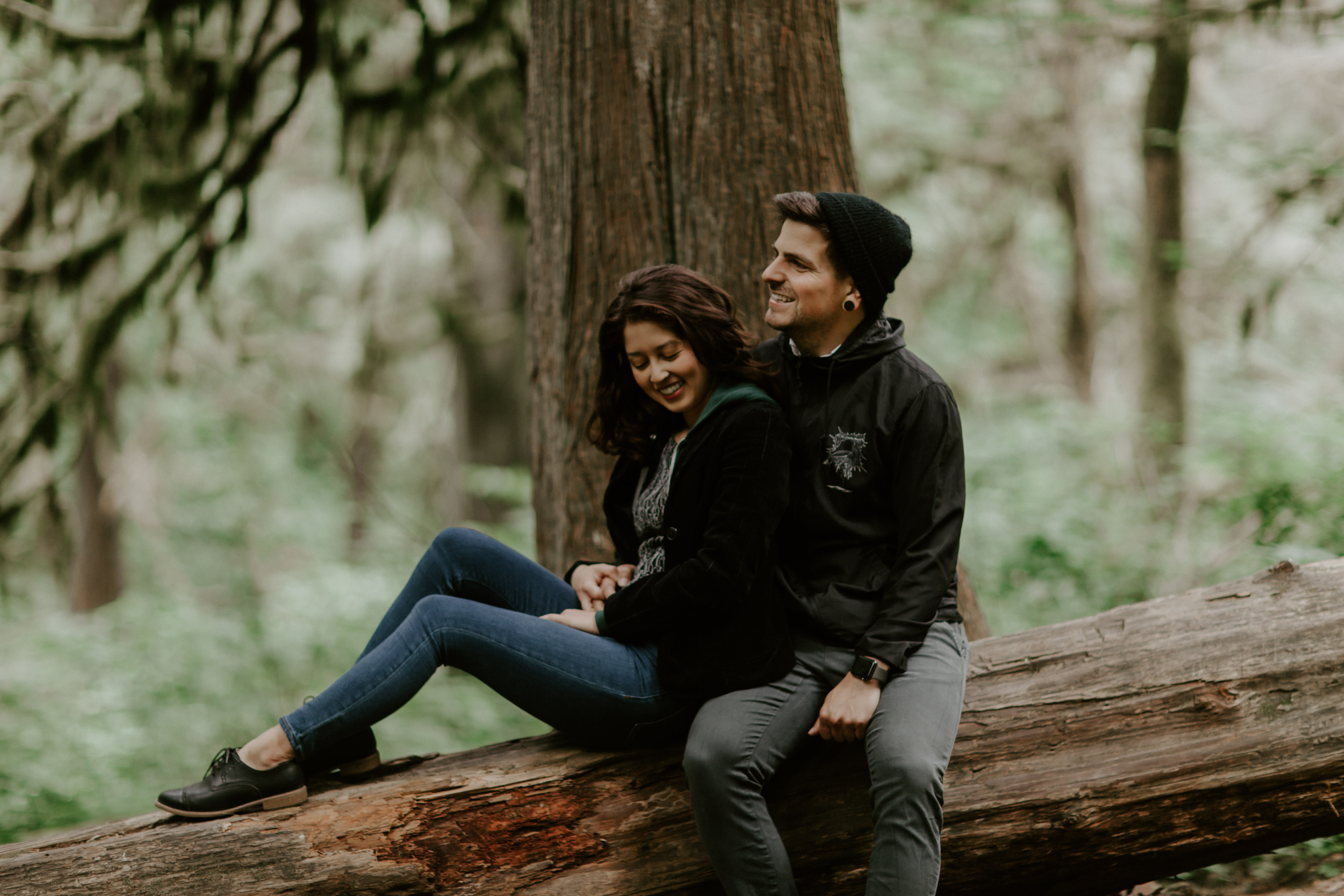 Jasmine and Chris sit on a downed tree along the trail at Latourell Falls in Oregon. Adventure photography in Portland Oregon by Sienna Plus Josh.