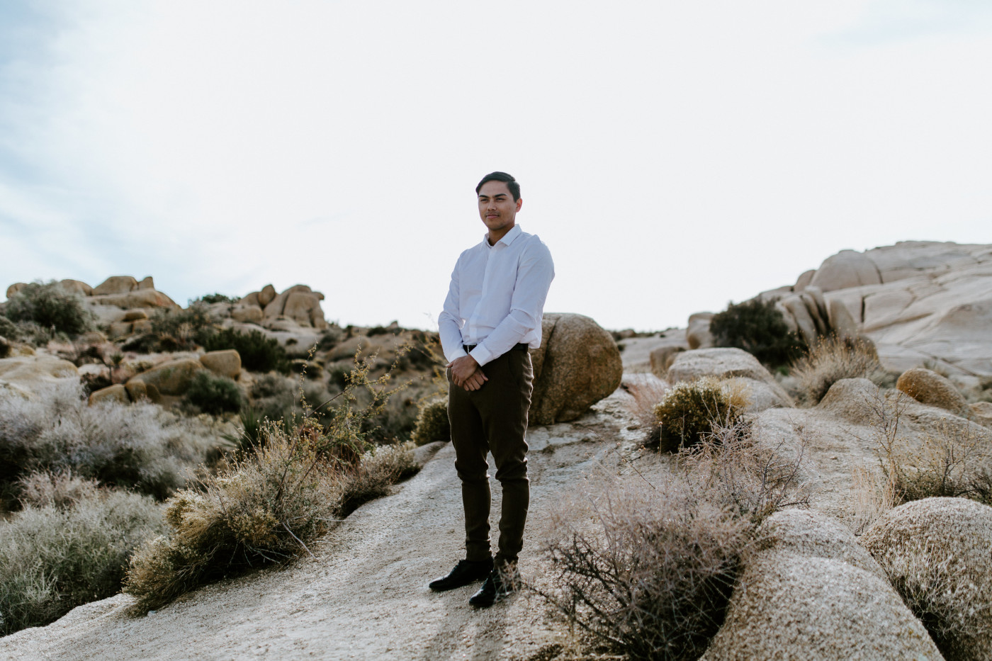 Zack stands on top of a rock in Joshua Tree.