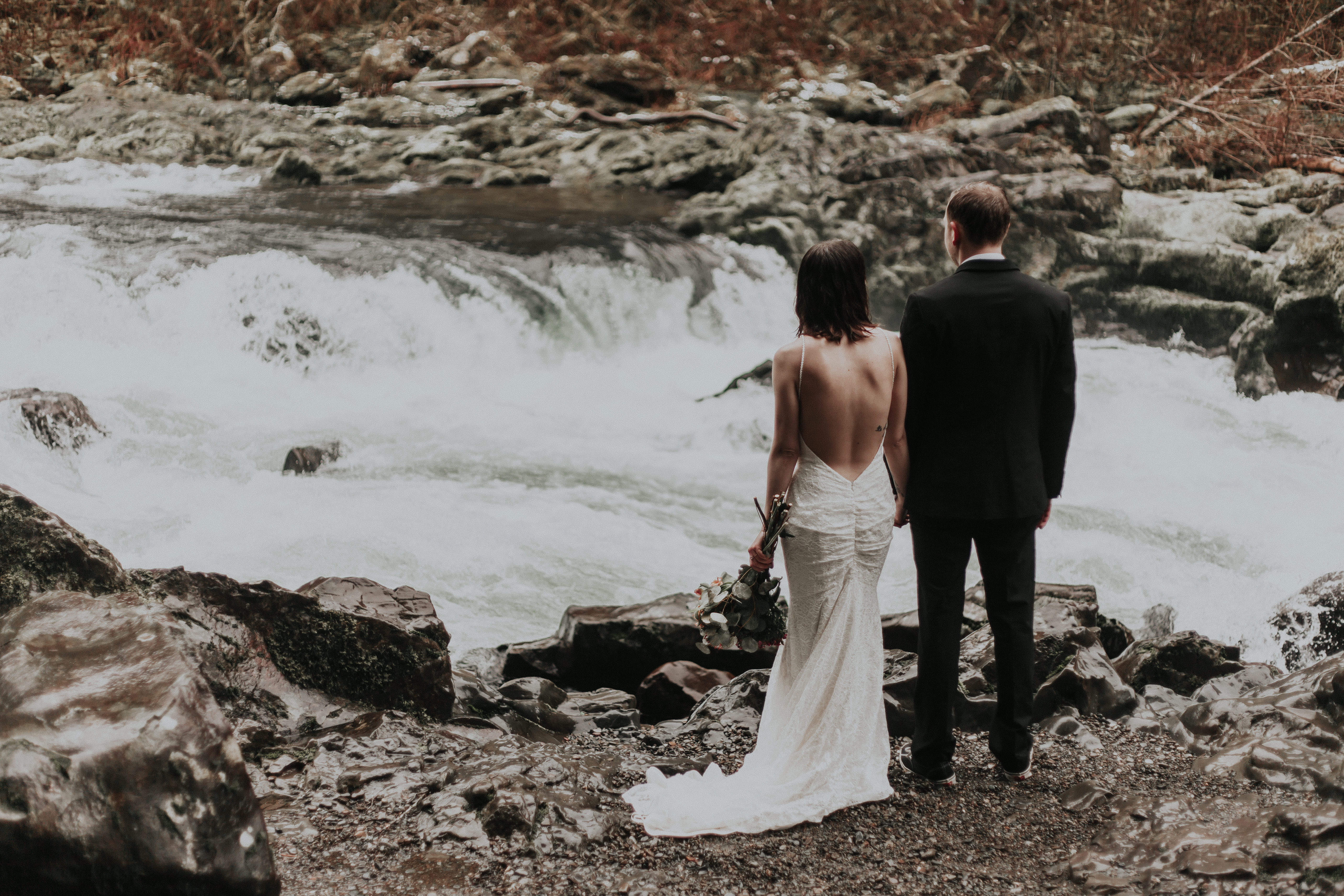 Paige and TJ standing near the waterfalls at Moulton Falls for the Washington Wedding.