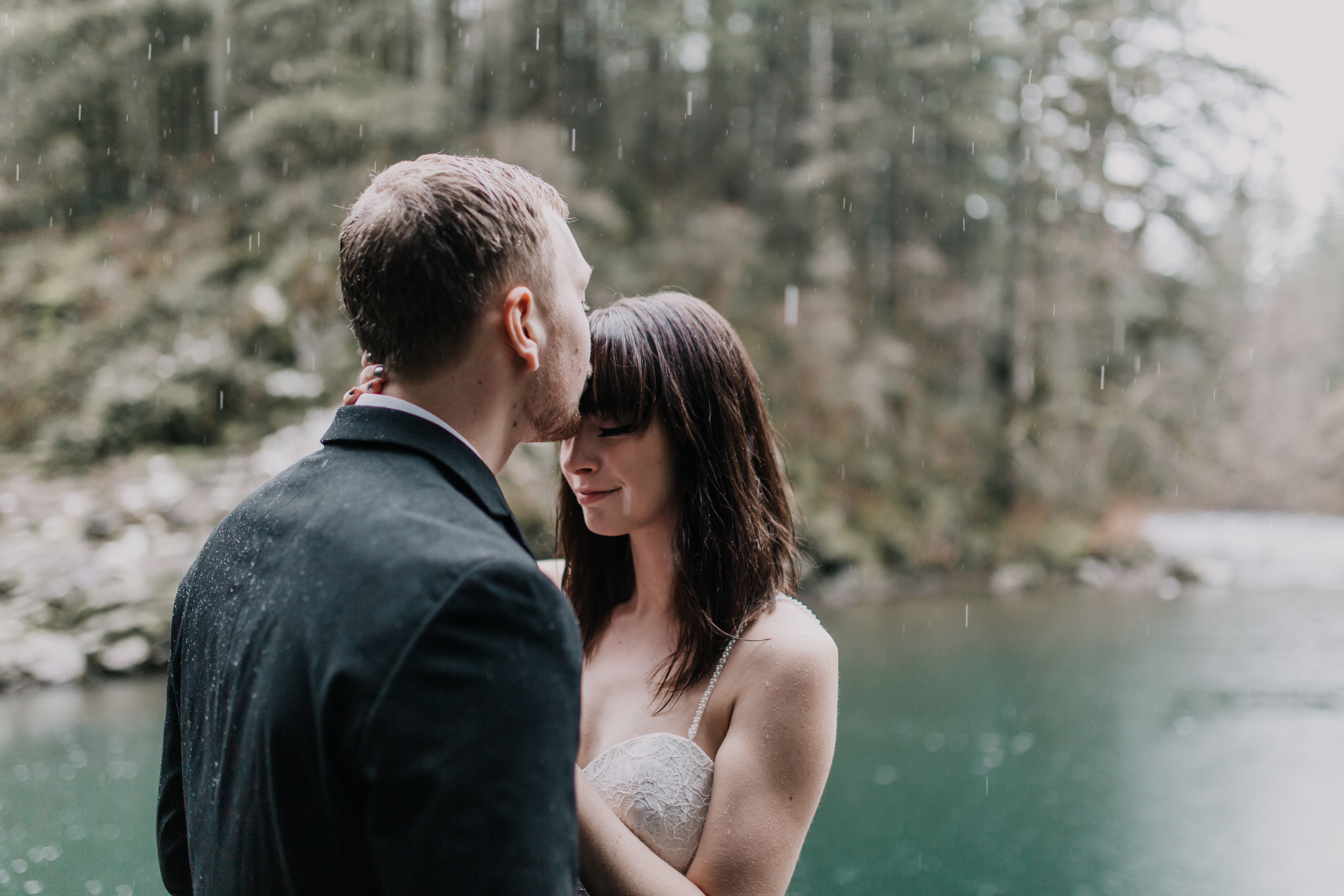 Paige and TJ sharing an intimate wedding moment in the rain at Moulton Falls for their adventure wedding in Washington.