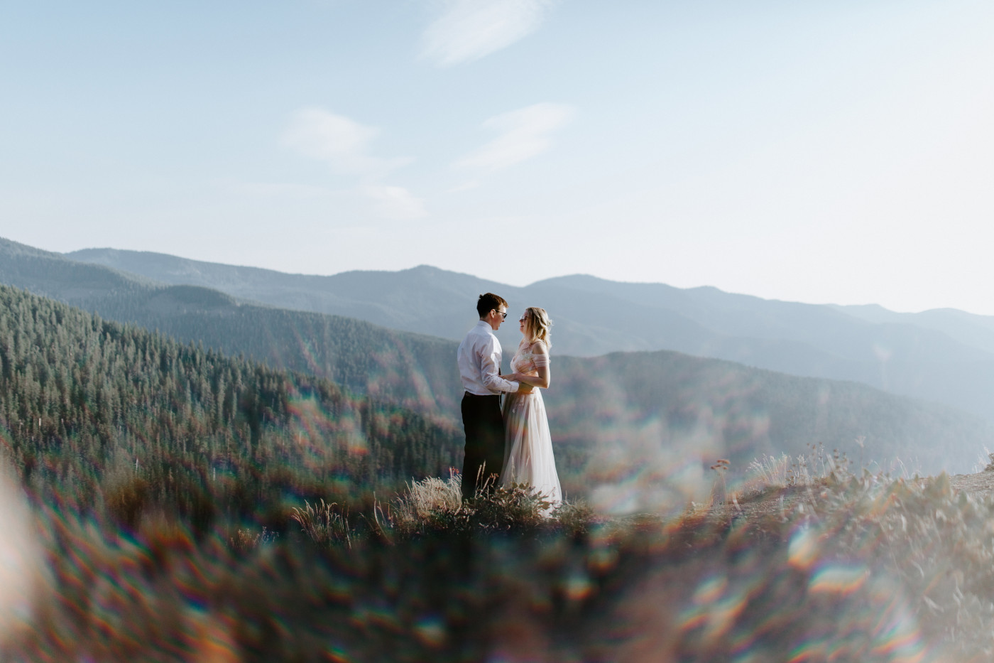 Kylie and Corey stand in front of a view of the woods.