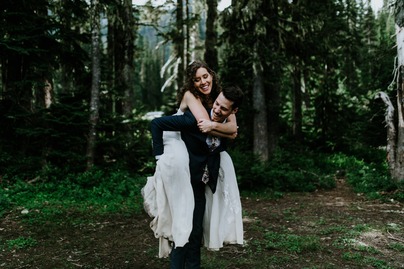 Chad gives Tasha a piggyback ride. Elopement photography at Mount Rainier by Sienna Plus Josh.