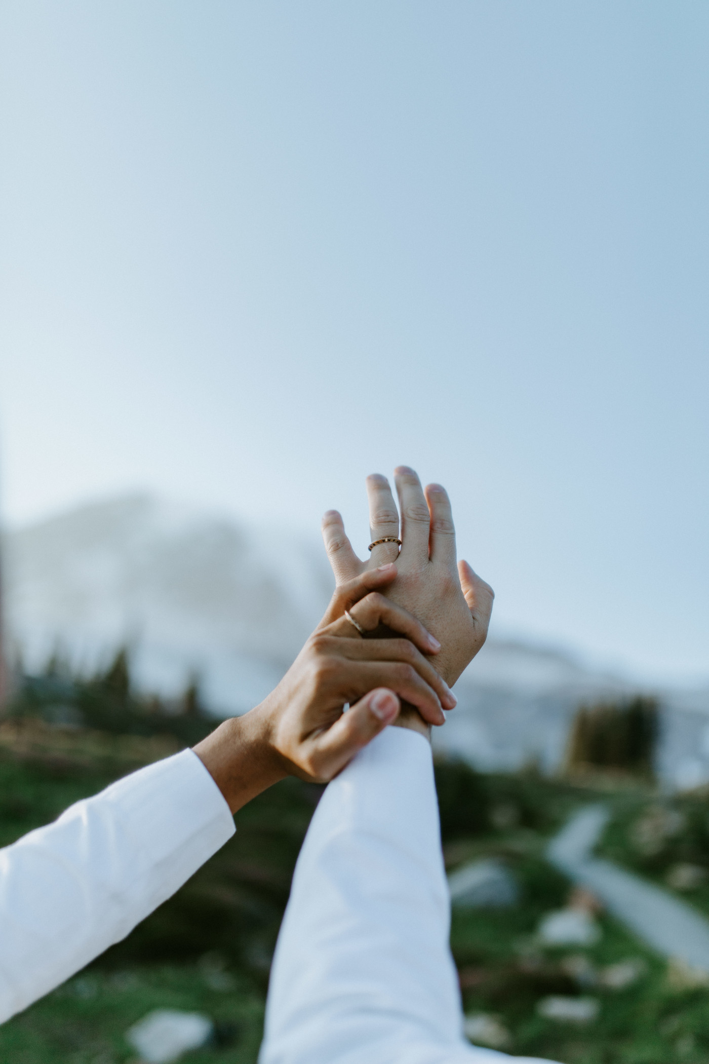 Fred and Brooks show their rings in front of Mount Rainier.